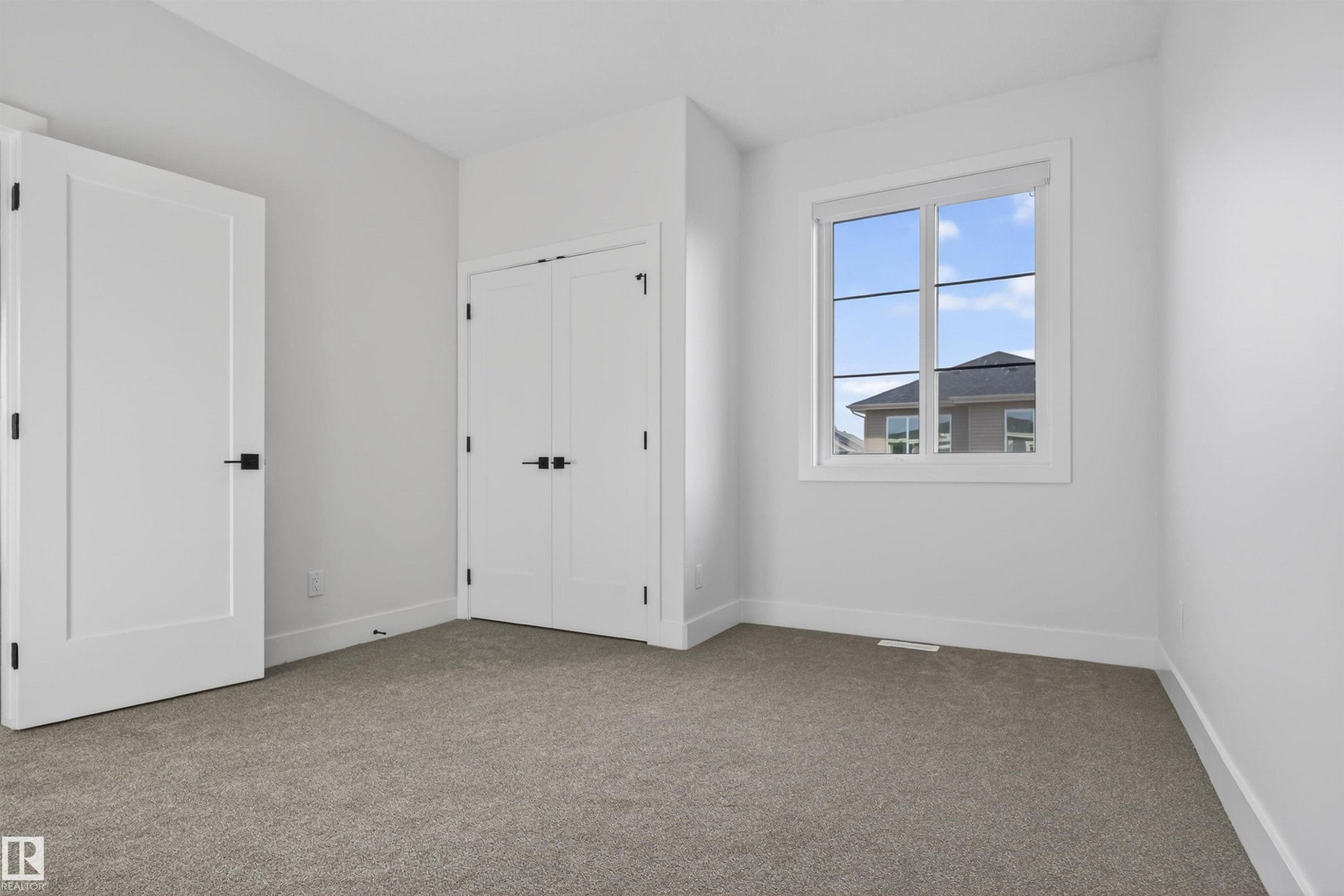 Neutral-toned carpeting complements the white walls and trim - 27 Redpoll Wynd, St. Albert, AB - Indoor Photo Showing Other Room