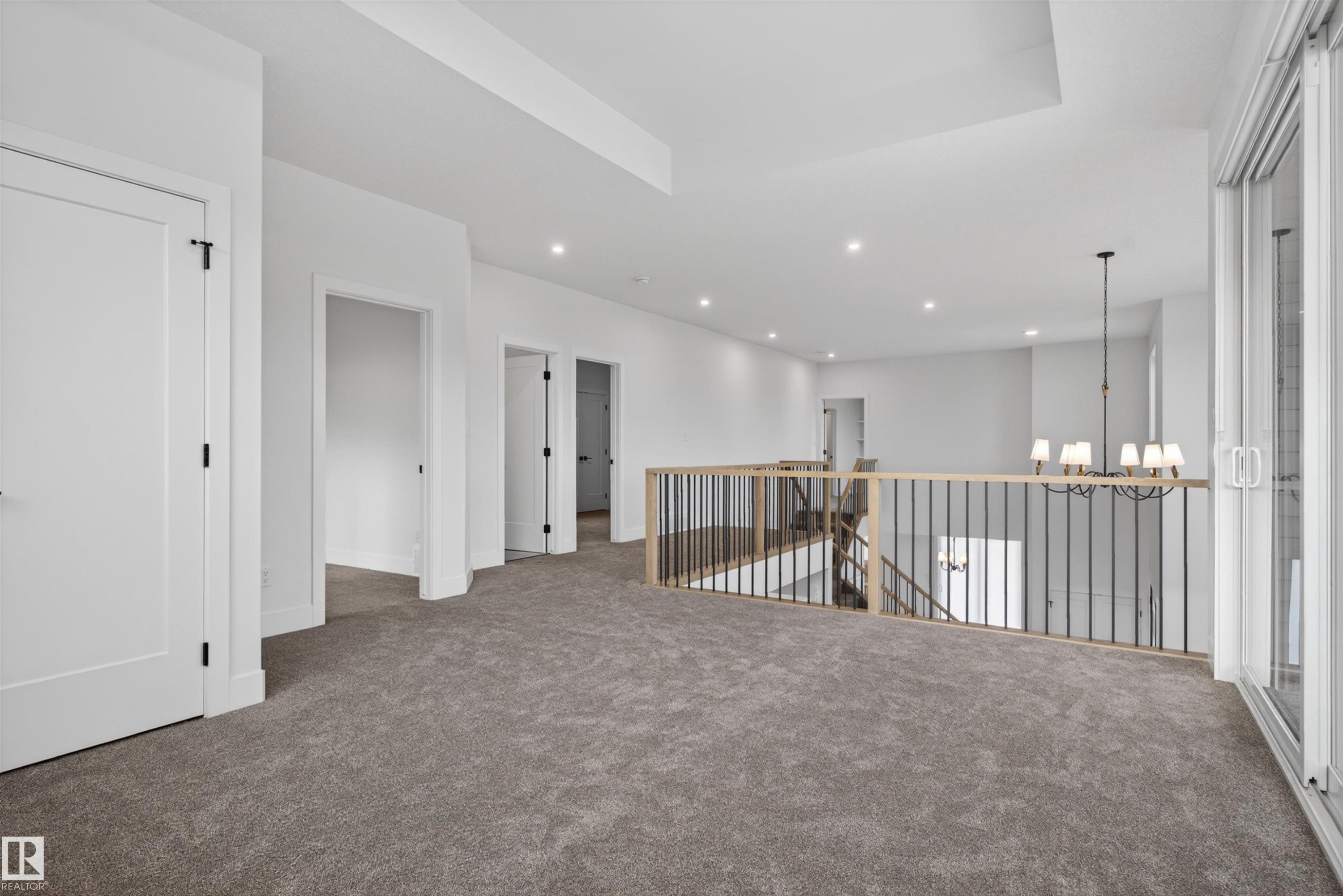 Spacious open loft area with plush gray carpeting - 27 Redpoll Wynd, St. Albert, AB - Indoor Photo Showing Other Room