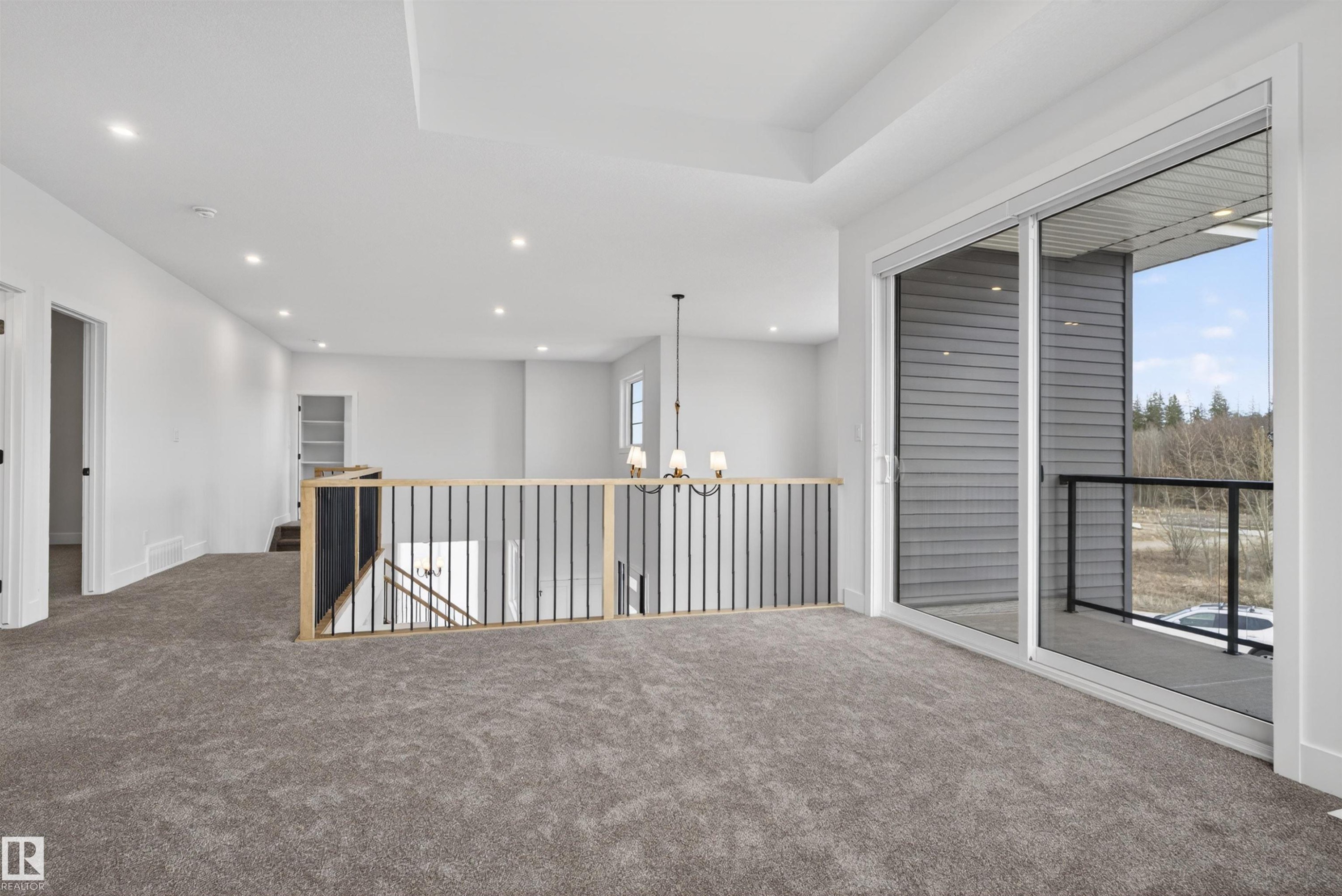 Expansive carpeted loft space featuring a tray ceiling with recessed lighting - 27 Redpoll Wynd, St. Albert, AB - Indoor Photo Showing Other Room