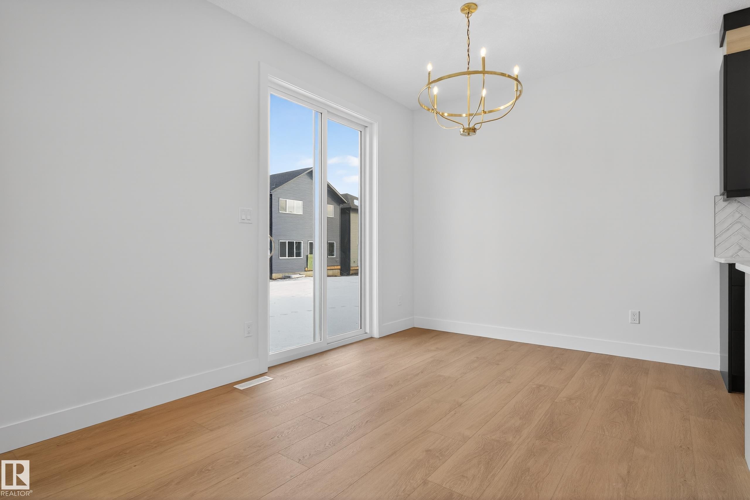 Unfurnished dining area featuring a chandelier and light wood-style floors - 19 Rosa Crescent, St. Albert, AB - Indoor Photo Showing Other Room With Fireplace