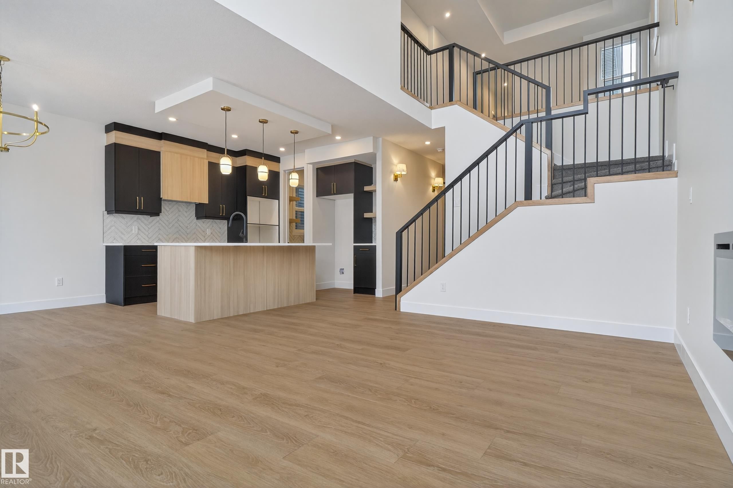 Kitchen featuring open floor plan, modern cabinets, light countertops, a center island with sink, and light wood finished floors - 19 Rosa Crescent, St. Albert, AB - Indoor Photo Showing Other Room