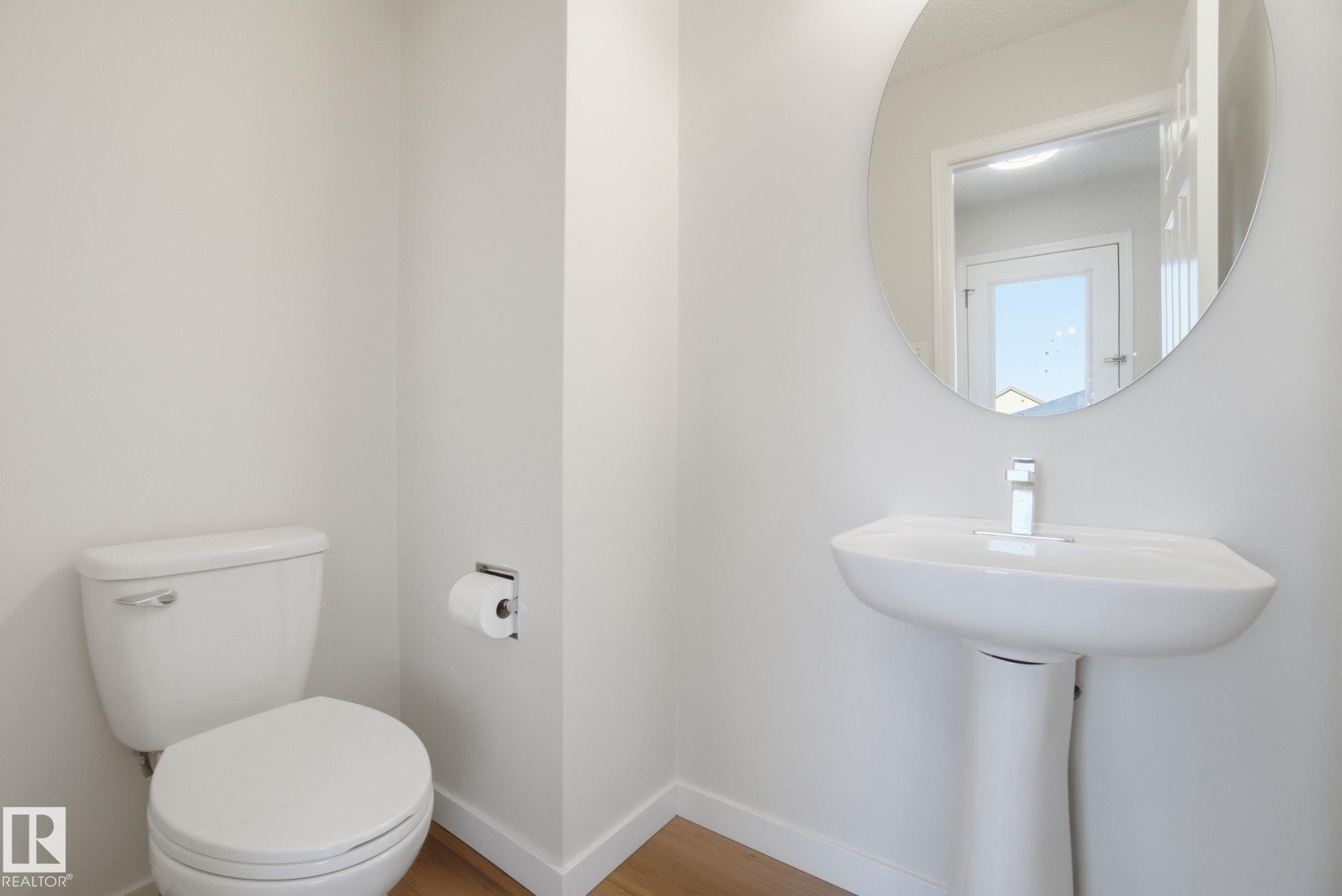 Half bathroom featuring toilet and wood finished floors - 3014 31 Avenue, Edmonton, AB - Indoor Photo Showing Bathroom
