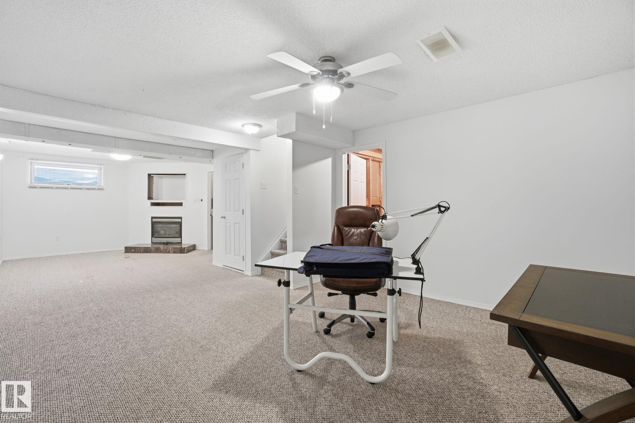 Basement with a glass covered fireplace and light carpet - 3014 31 Avenue, Edmonton, AB - Indoor