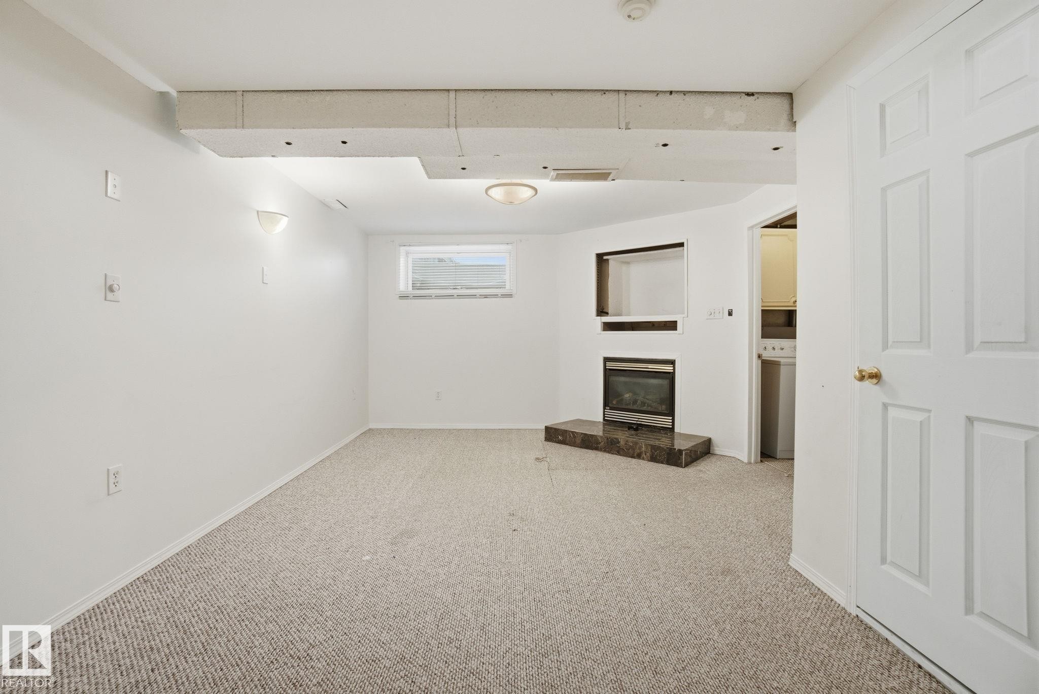 Basement with a glass covered fireplace and light carpet - 3014 31 Avenue, Edmonton, AB - Indoor Photo Showing Other Room