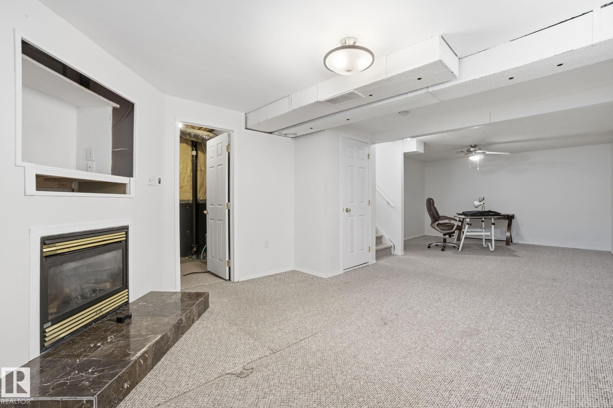 Basement with a glass covered fireplace and light carpet - 3014 31 Avenue, Edmonton, AB - Indoor With Fireplace