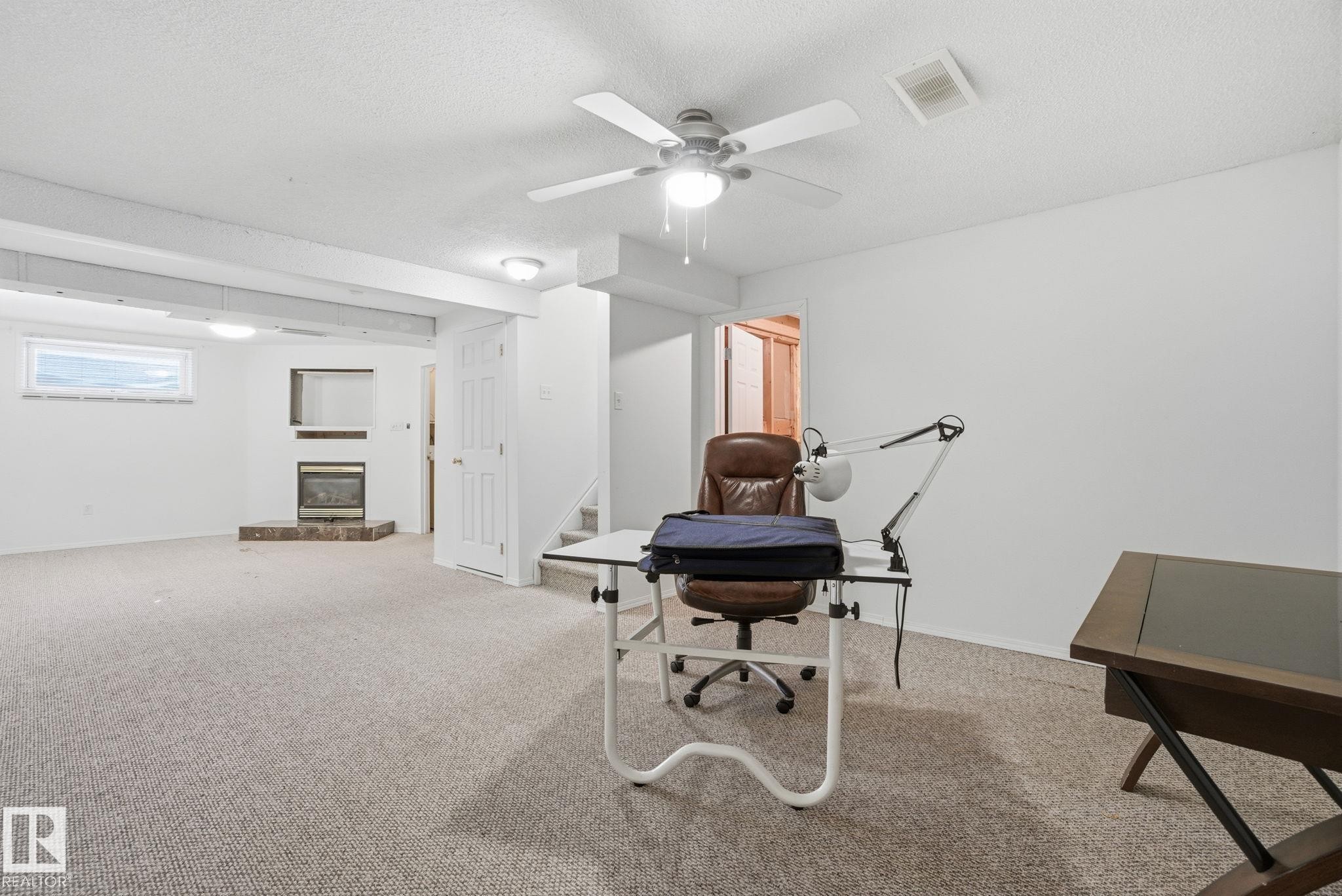 Basement with a glass covered fireplace and light carpet - 3014 31 Avenue, Edmonton, AB - Indoor