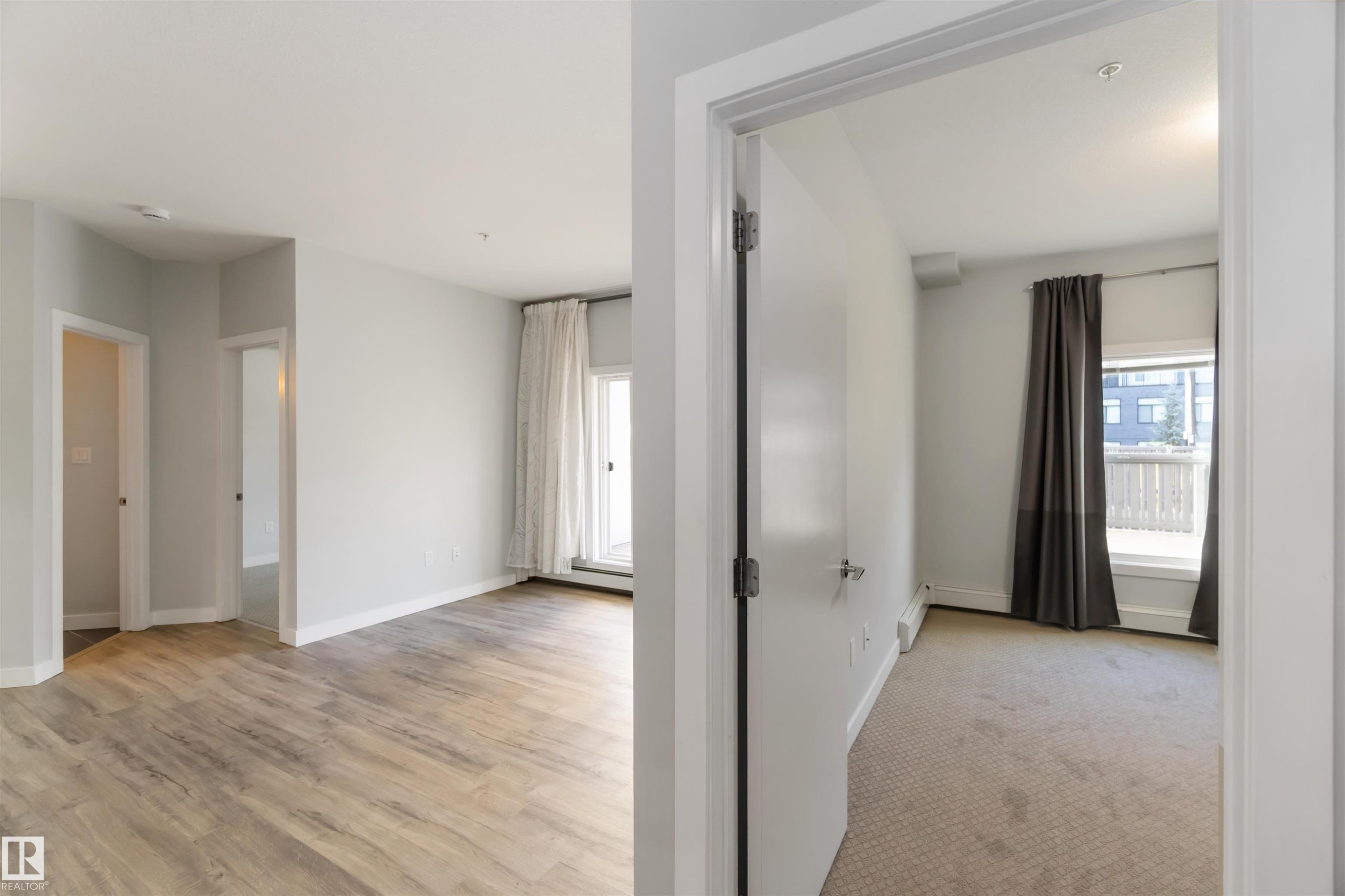 Unfurnished room with light wood-style flooring and light colored carpet - 107 10611 117 Street, Edmonton, AB - Indoor Photo Showing Other Room