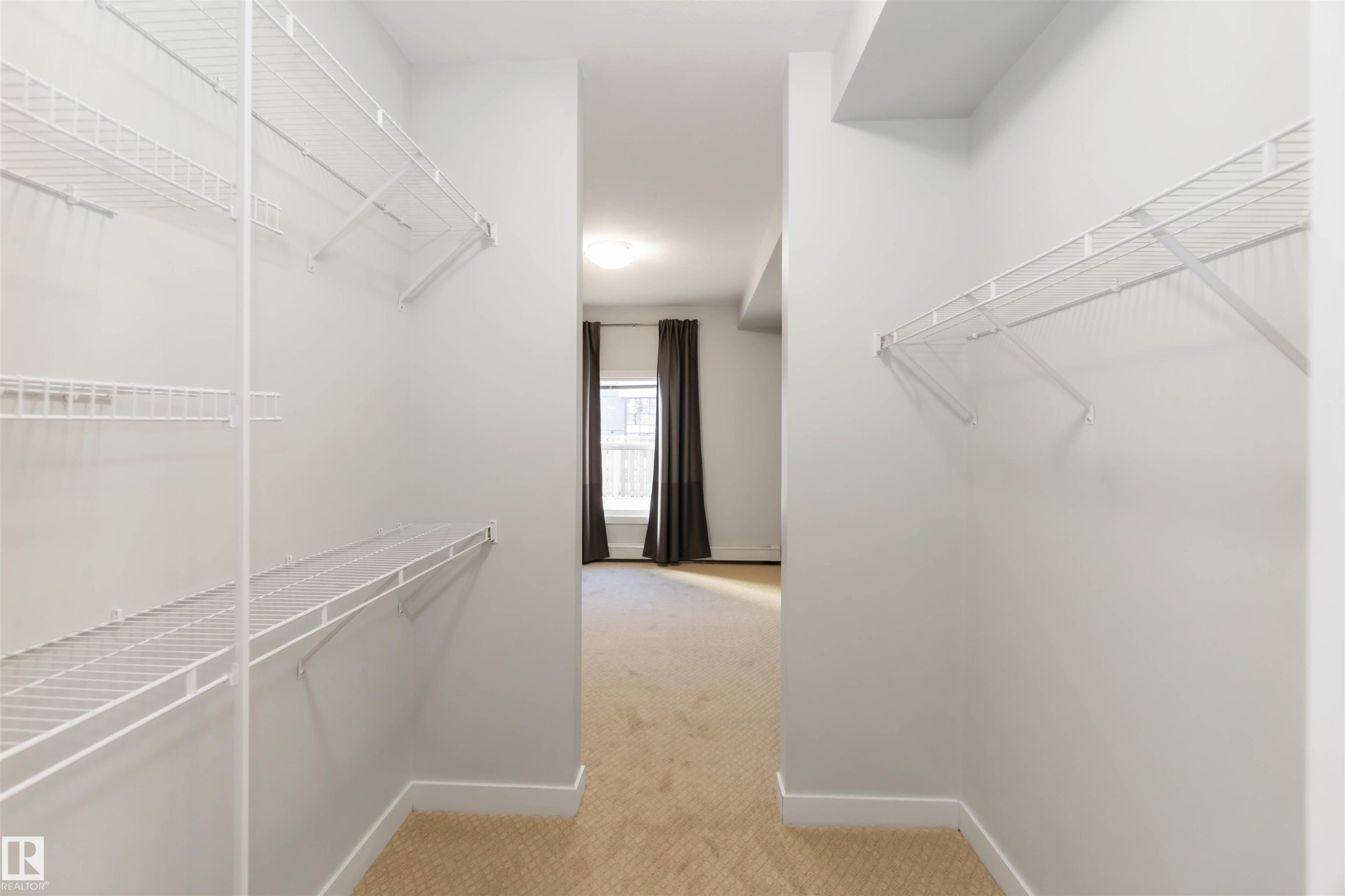 Walk in closet with light carpet - 107 10611 117 Street, Edmonton, AB - Indoor With Storage