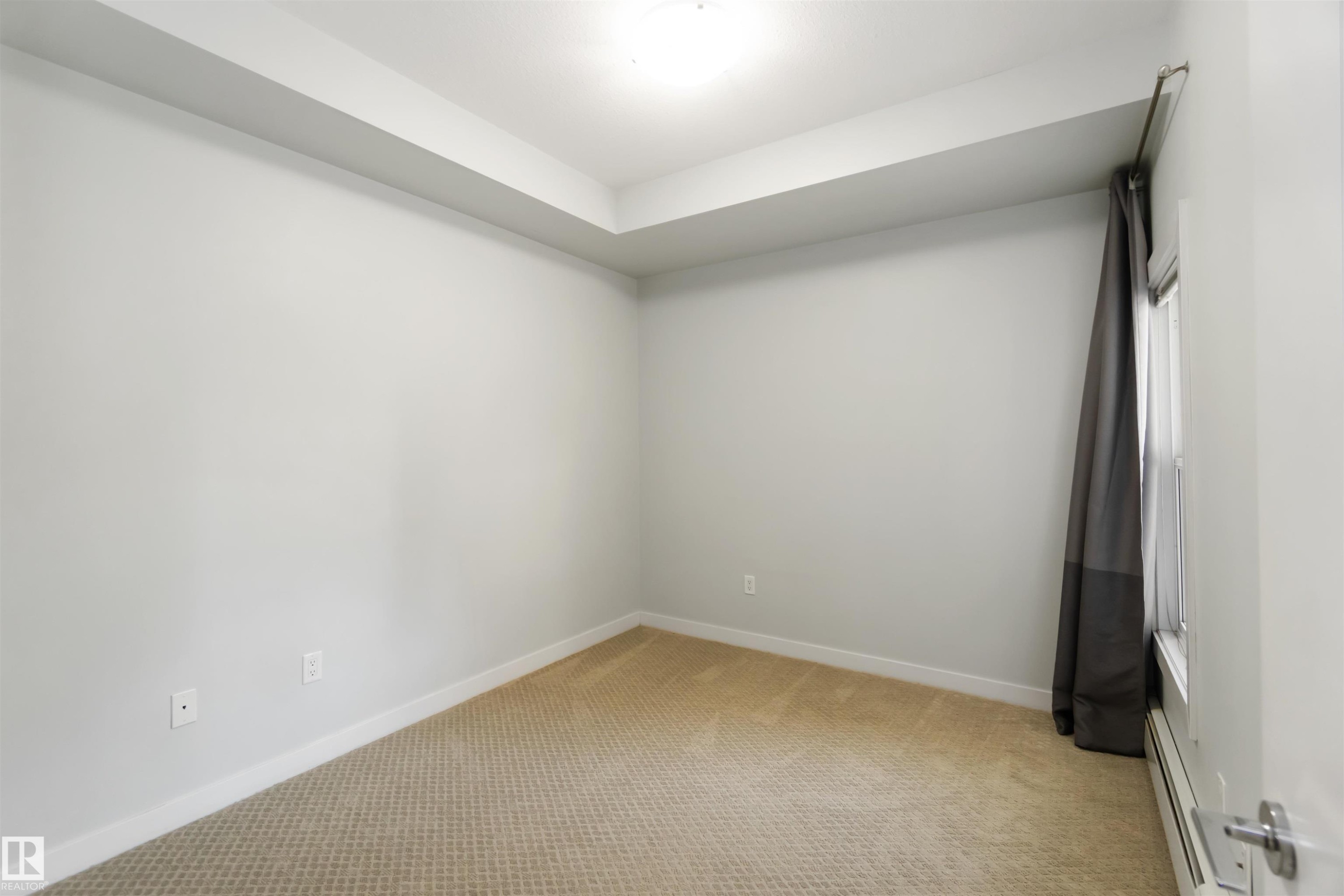 Spare room with light colored carpet and a baseboard radiator - 107 10611 117 Street, Edmonton, AB - Indoor Photo Showing Other Room