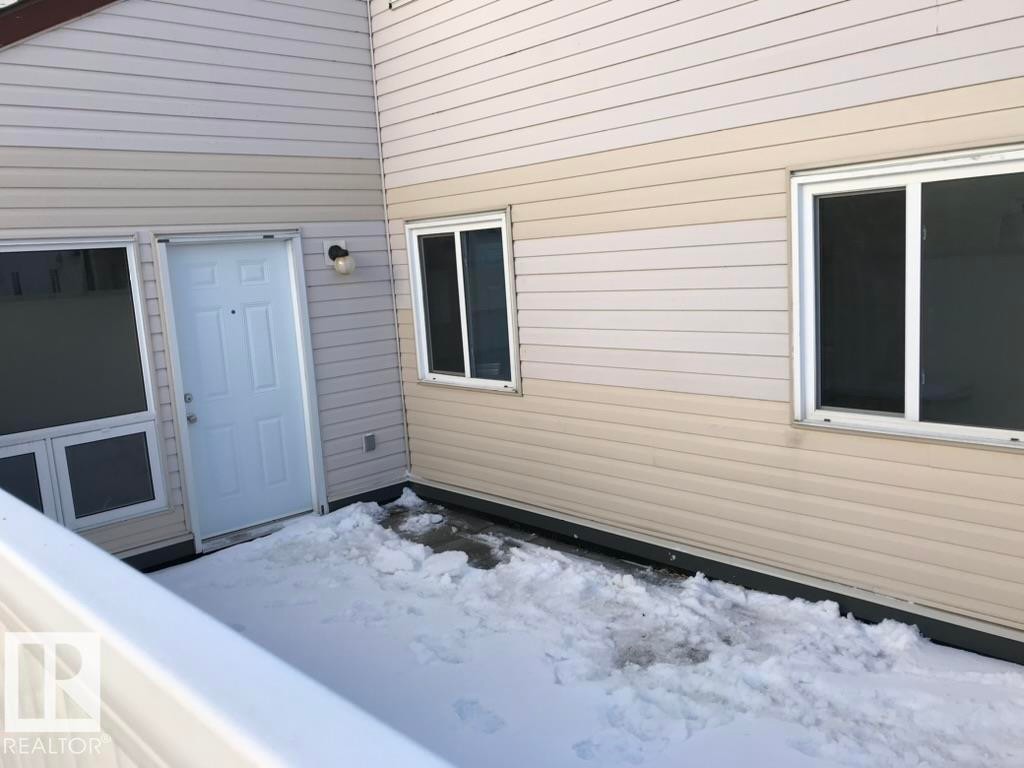 View of snow covered private deck with property entrance to living room - 23 Lancaster Terrace, Edmonton, AB - Outdoor With Exterior