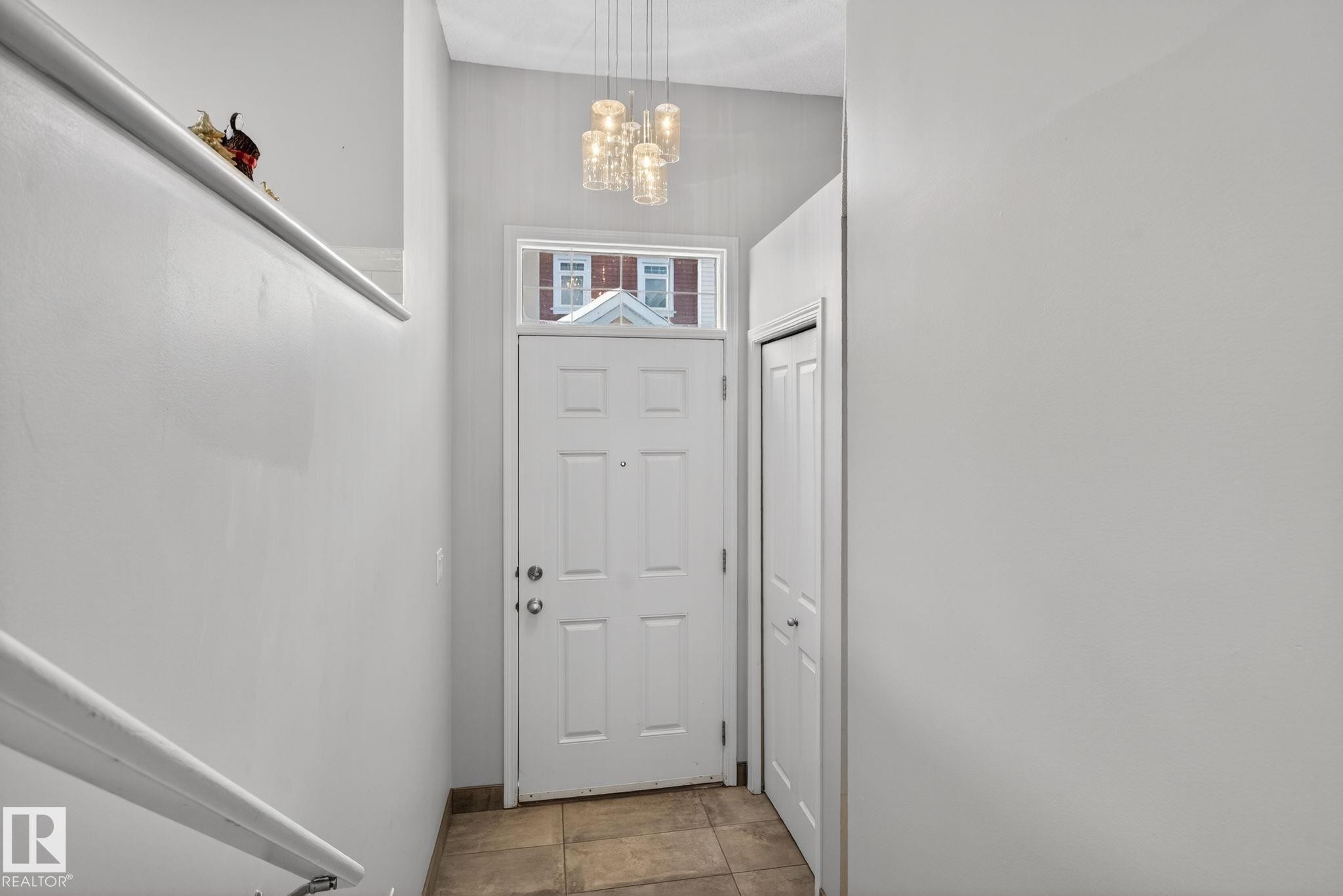 Doorway to outside featuring a chandelier and tile patterned flooring - 60 1804 70 Street, Edmonton, AB - Indoor Photo Showing Other Room