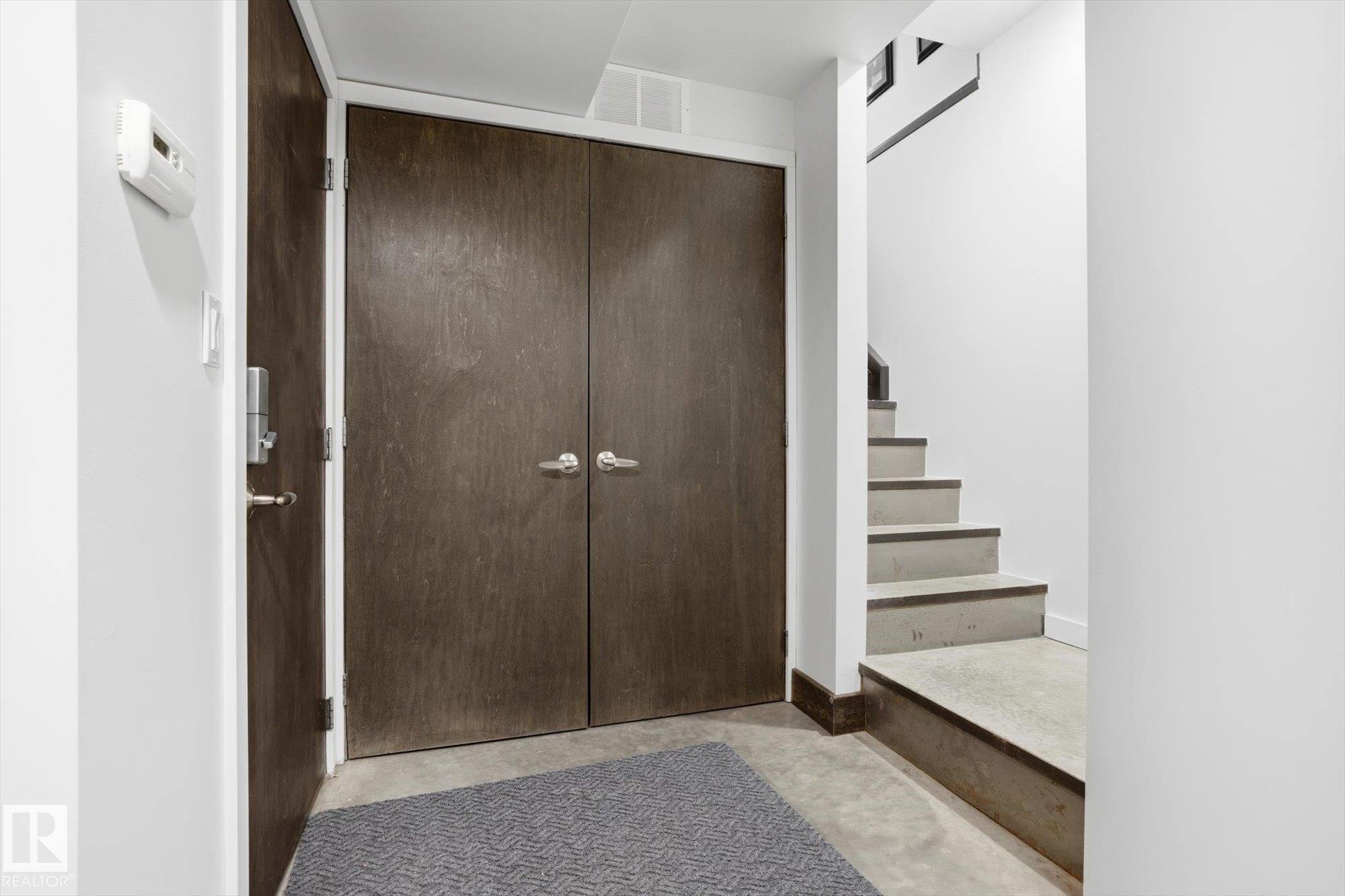 Foyer entrance featuring concrete floors and stairway - 9012 98 Street, Edmonton, AB - Indoor Photo Showing Other Room
