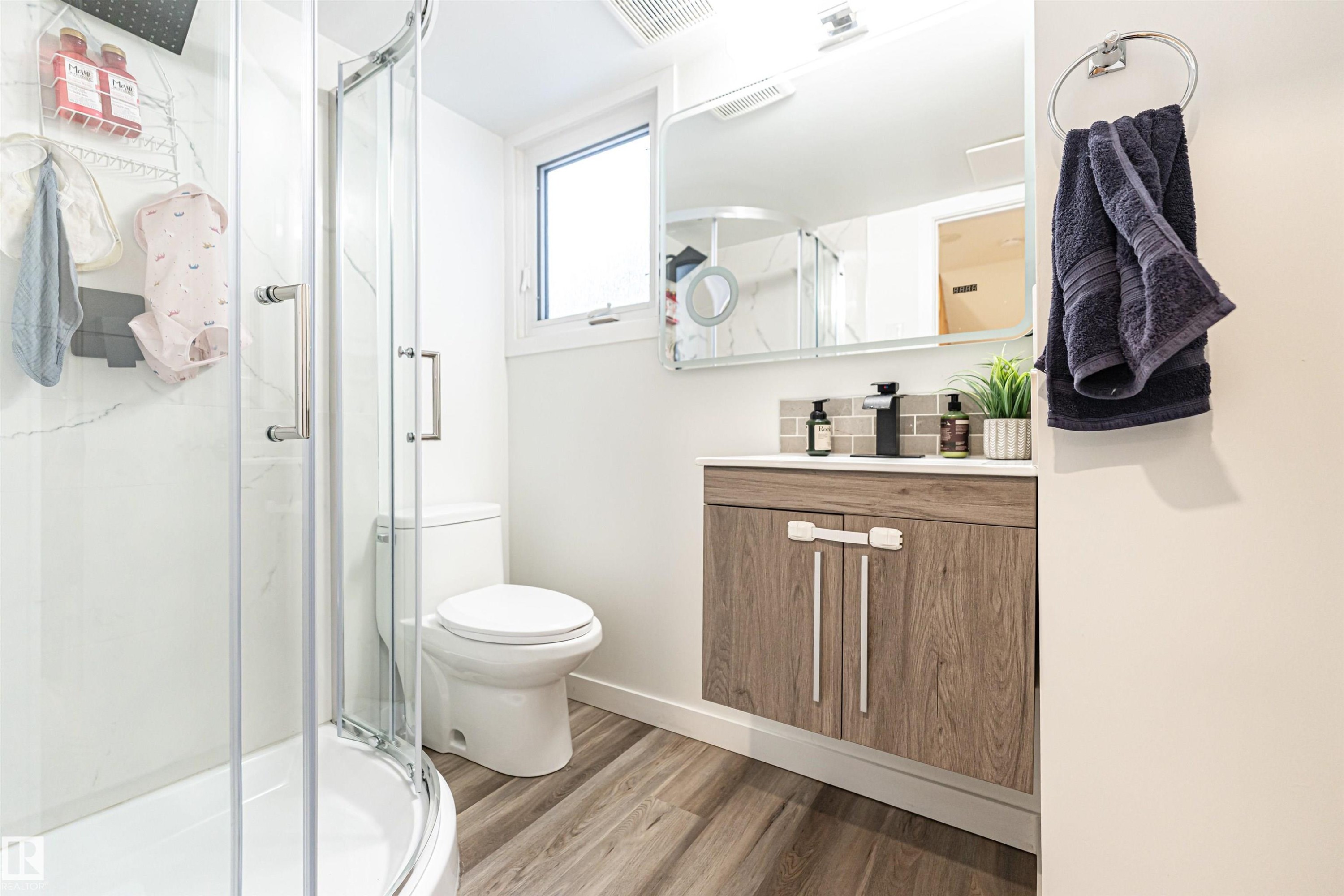 Bathroom featuring vanity, a stall shower, and light wood-type flooring - 17716 84 Avenue, Edmonton, AB - Indoor Photo Showing Bathroom