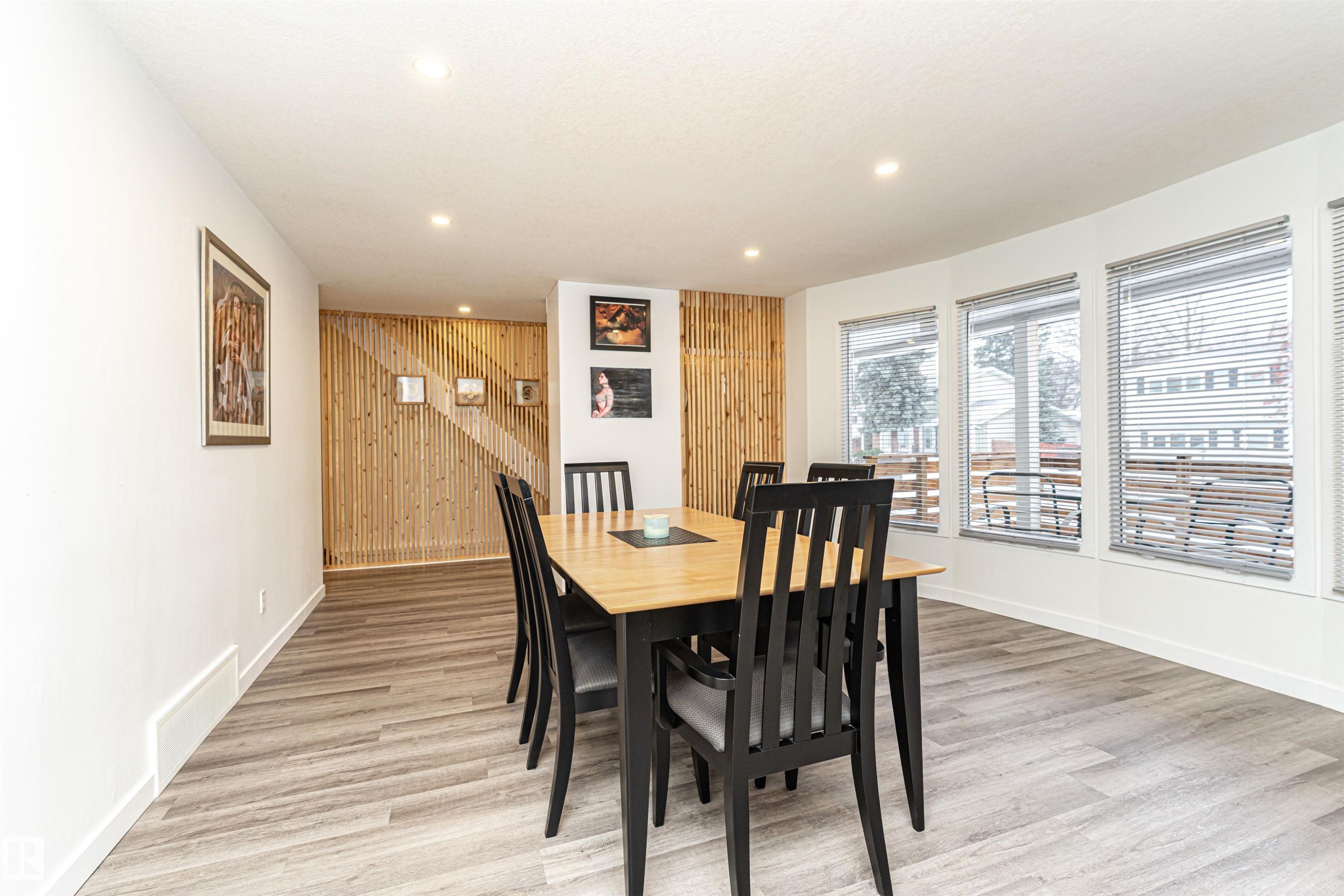 Dining area with wood walls, an accent wall, light wood-style floors, and recessed lighting - 17716 84 Avenue, Edmonton, AB - Indoor Photo Showing Dining Room