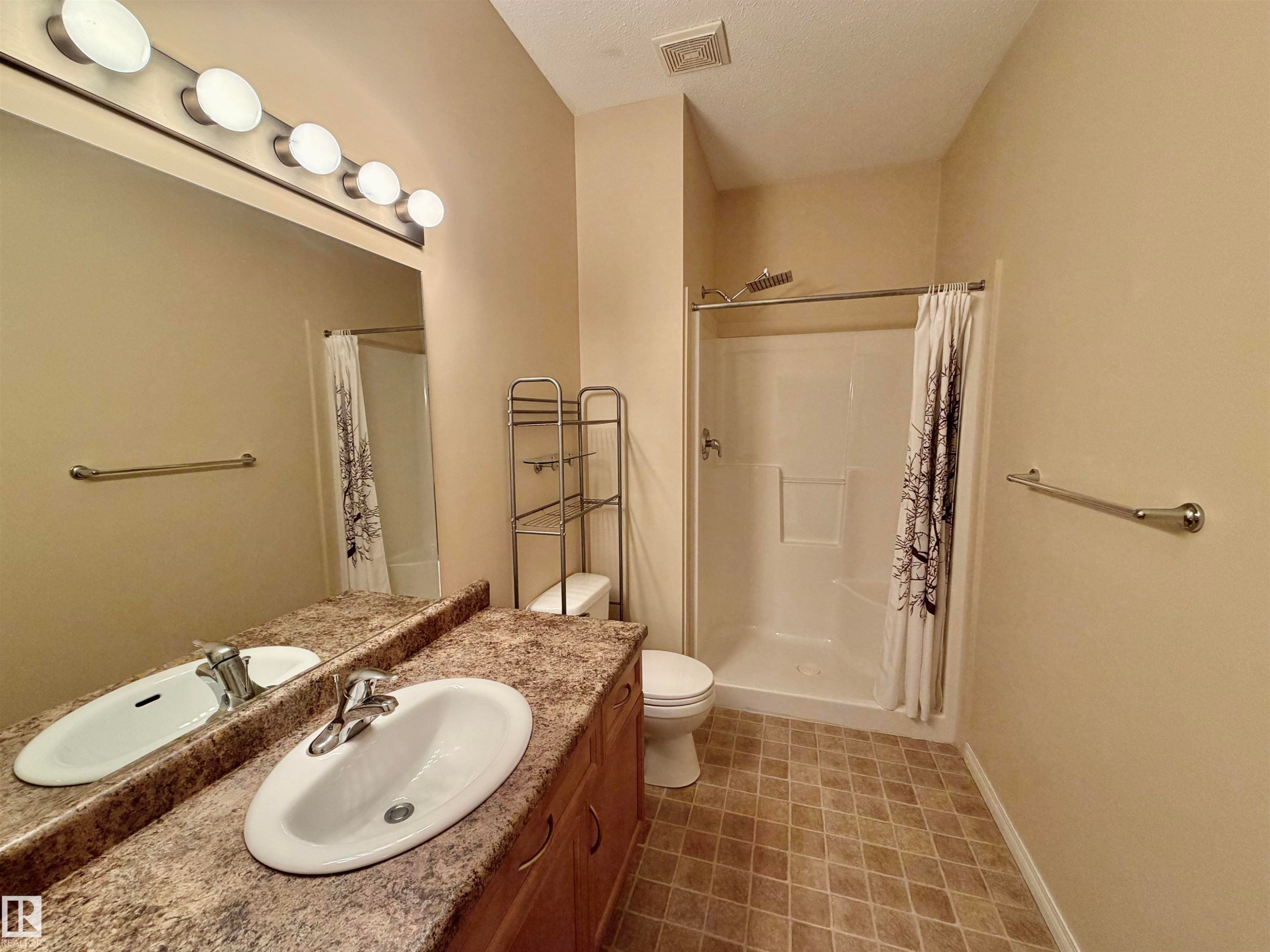 Full bathroom with a stall shower, vanity, a textured ceiling, and light flooring - 321 4304 139 Avenue, Edmonton, AB - Indoor Photo Showing Bathroom
