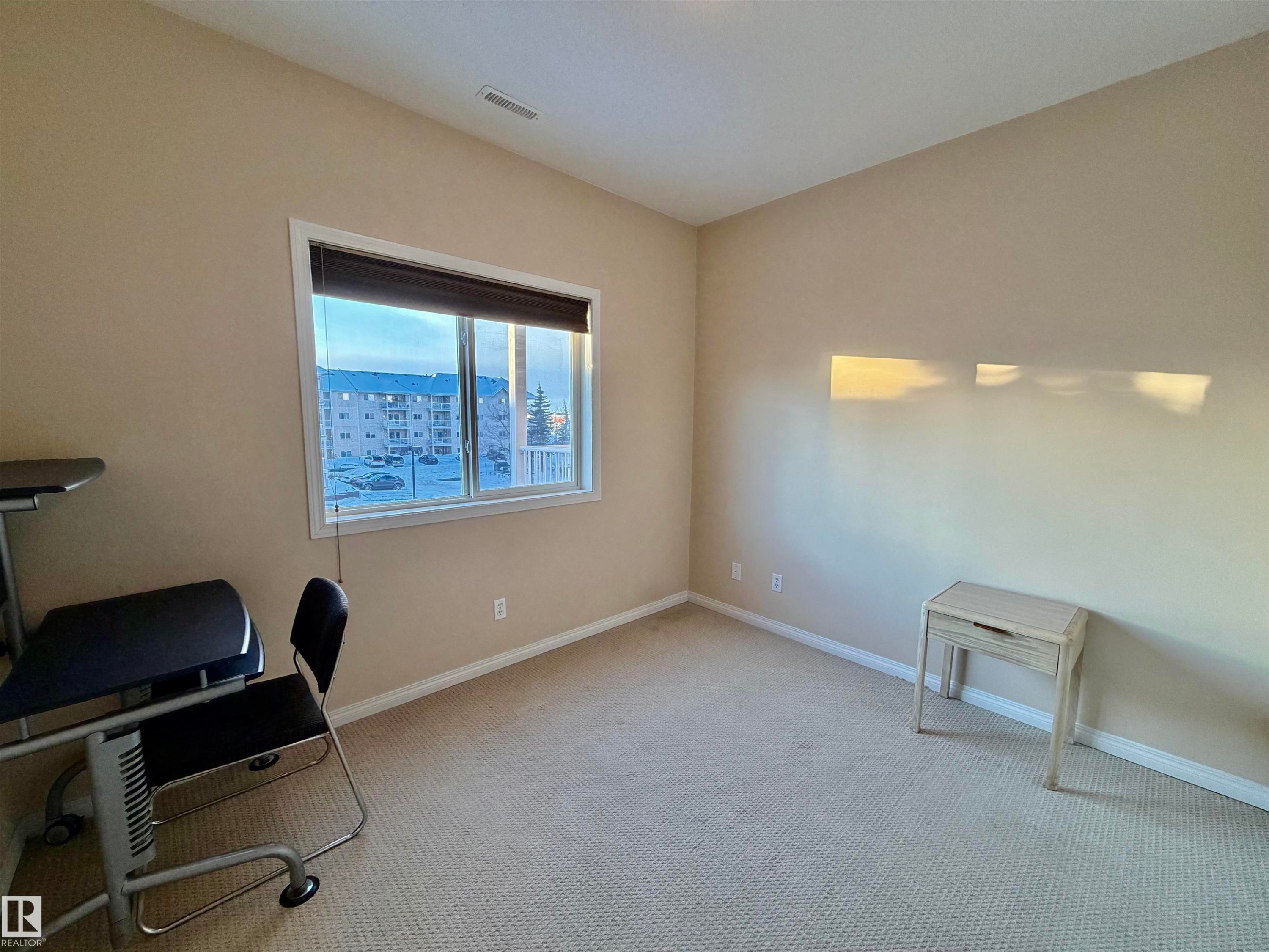 Unfurnished office featuring baseboards and carpet flooring - 321 4304 139 Avenue, Edmonton, AB - Indoor