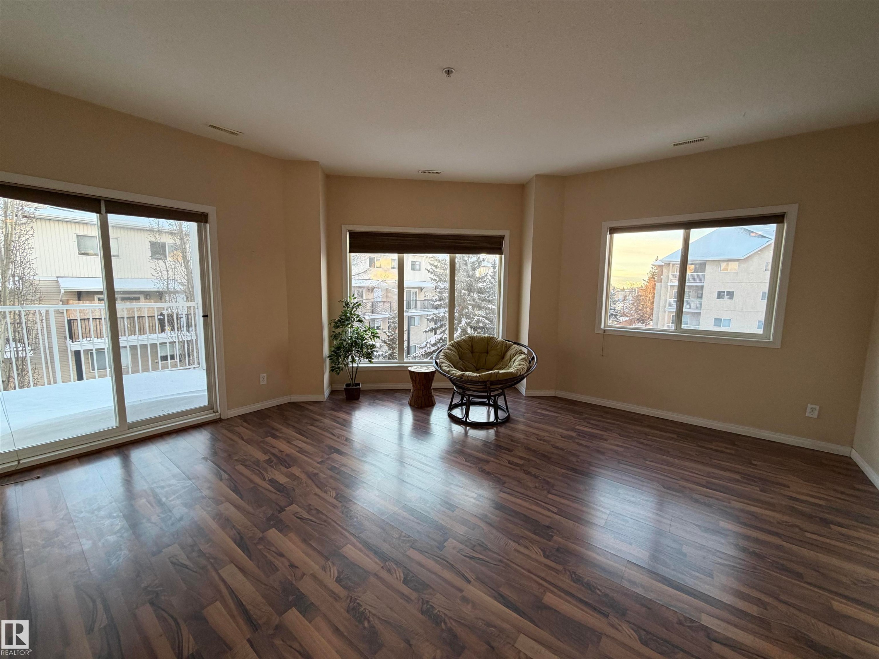 Sitting room with dark wood-style floors and plenty of natural light - 321 4304 139 Avenue, Edmonton, AB - Indoor