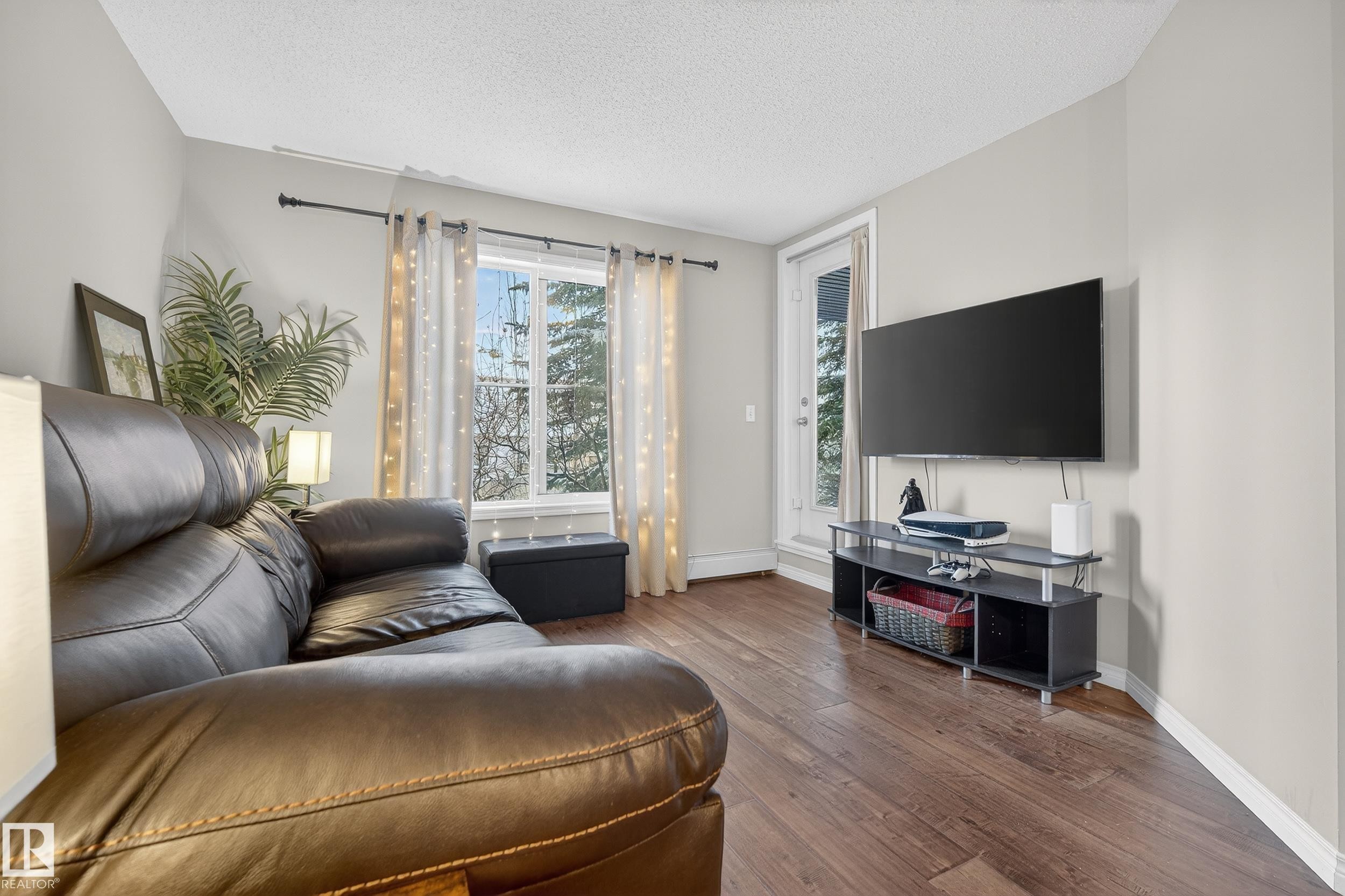 Living room with hardwood / wood-style flooring and a textured ceiling - 108 534 Watt Boulevard, Edmonton, AB - Indoor Photo Showing Living Room