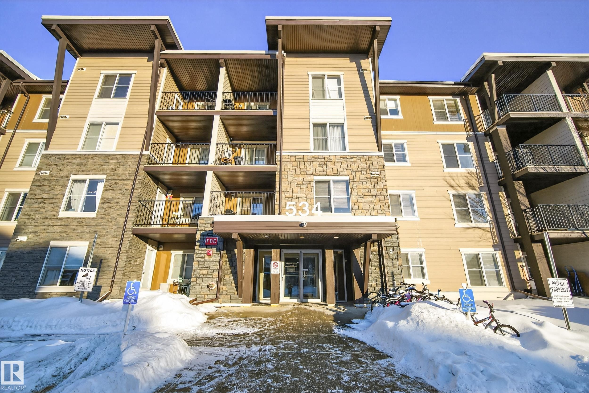 Snow covered building with a view of apartment building / complex - 108 534 Watt Boulevard, Edmonton, AB - Outdoor With Facade