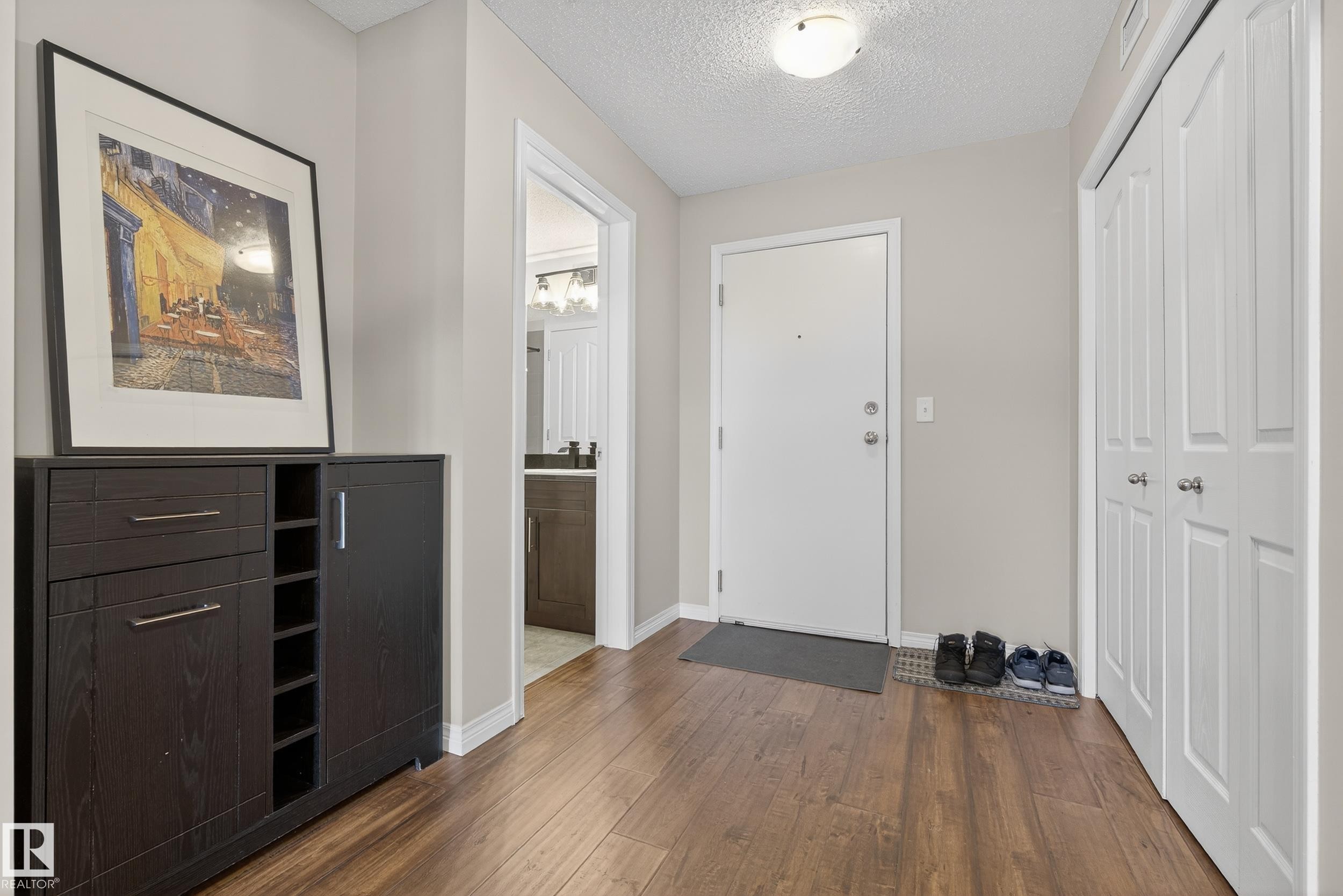 Foyer with dark wood-style floors and a textured ceiling - 108 534 Watt Boulevard, Edmonton, AB - Indoor Photo Showing Other Room