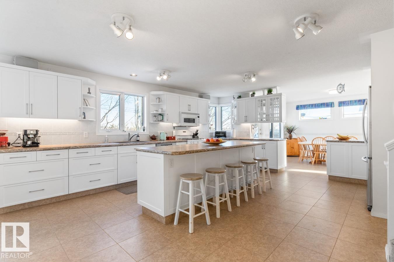Kitchen with white cabinetry, a kitchen breakfast bar, open shelves, and a kitchen island - 6508 109 Avenue, Edmonton, AB - Indoor Photo Showing Kitchen With Upgraded Kitchen