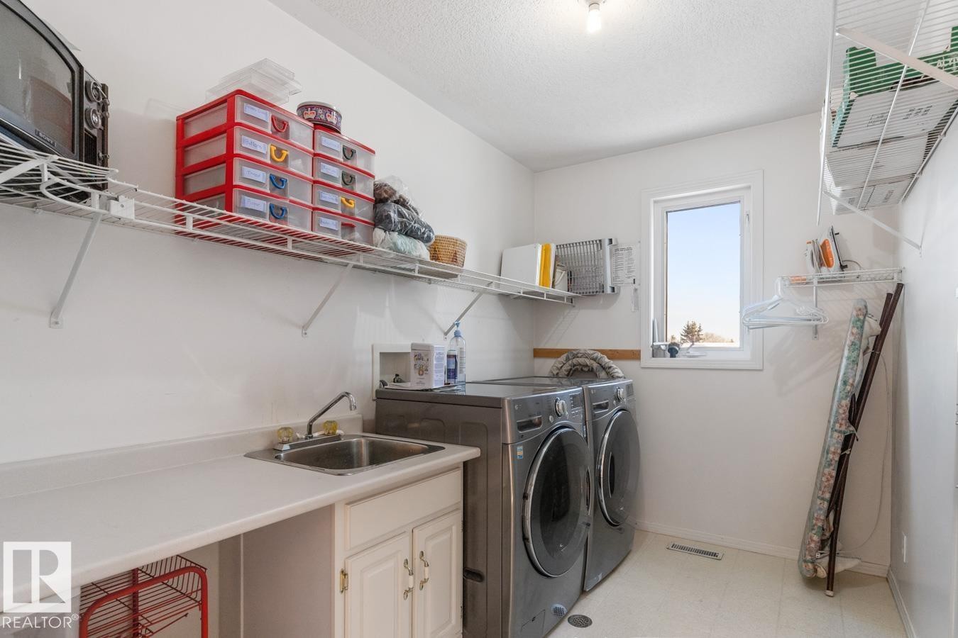 Laundry room with light flooring, washer and clothes dryer, and a textured ceiling - 6508 109 Avenue, Edmonton, AB - Indoor Photo Showing Laundry Room