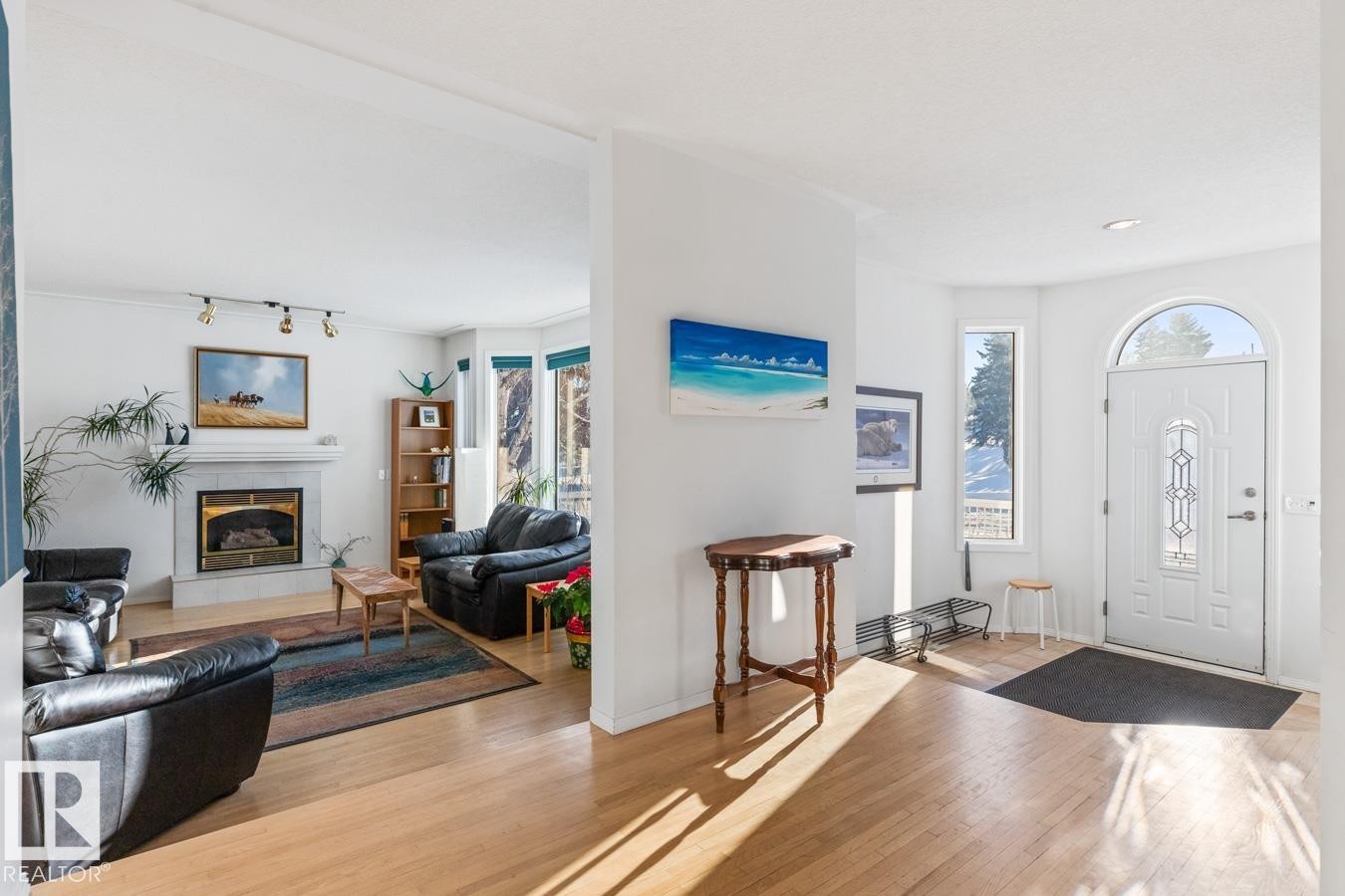 Foyer entrance featuring a fireplace and wood finished floors - 6508 109 Avenue, Edmonton, AB - Indoor Photo Showing Living Room With Fireplace