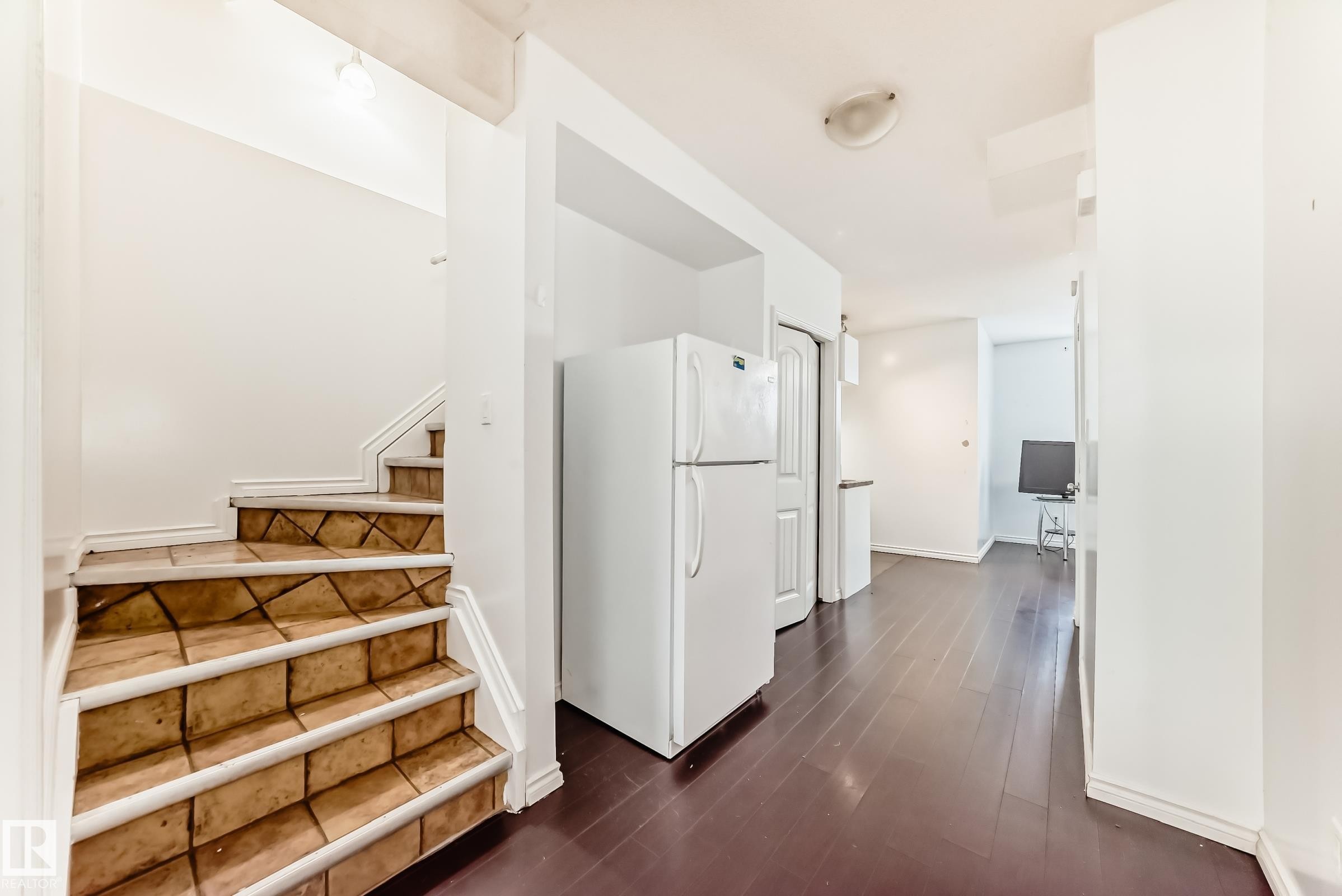 Hallway with dark wood-style flooring, stairway, and an office area - 10316 162 Street Nw, Edmonton, AB - Indoor Photo Showing Other Room