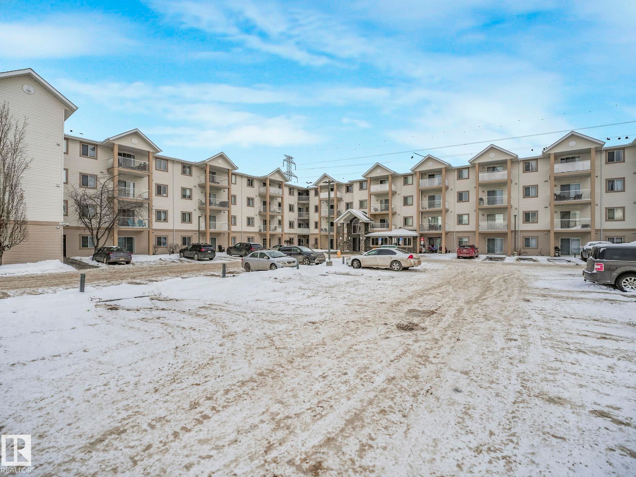 Snow covered building with a view of apartment building / complex - 210 245 Edwards Drive, Edmonton, AB - Outdoor With Facade