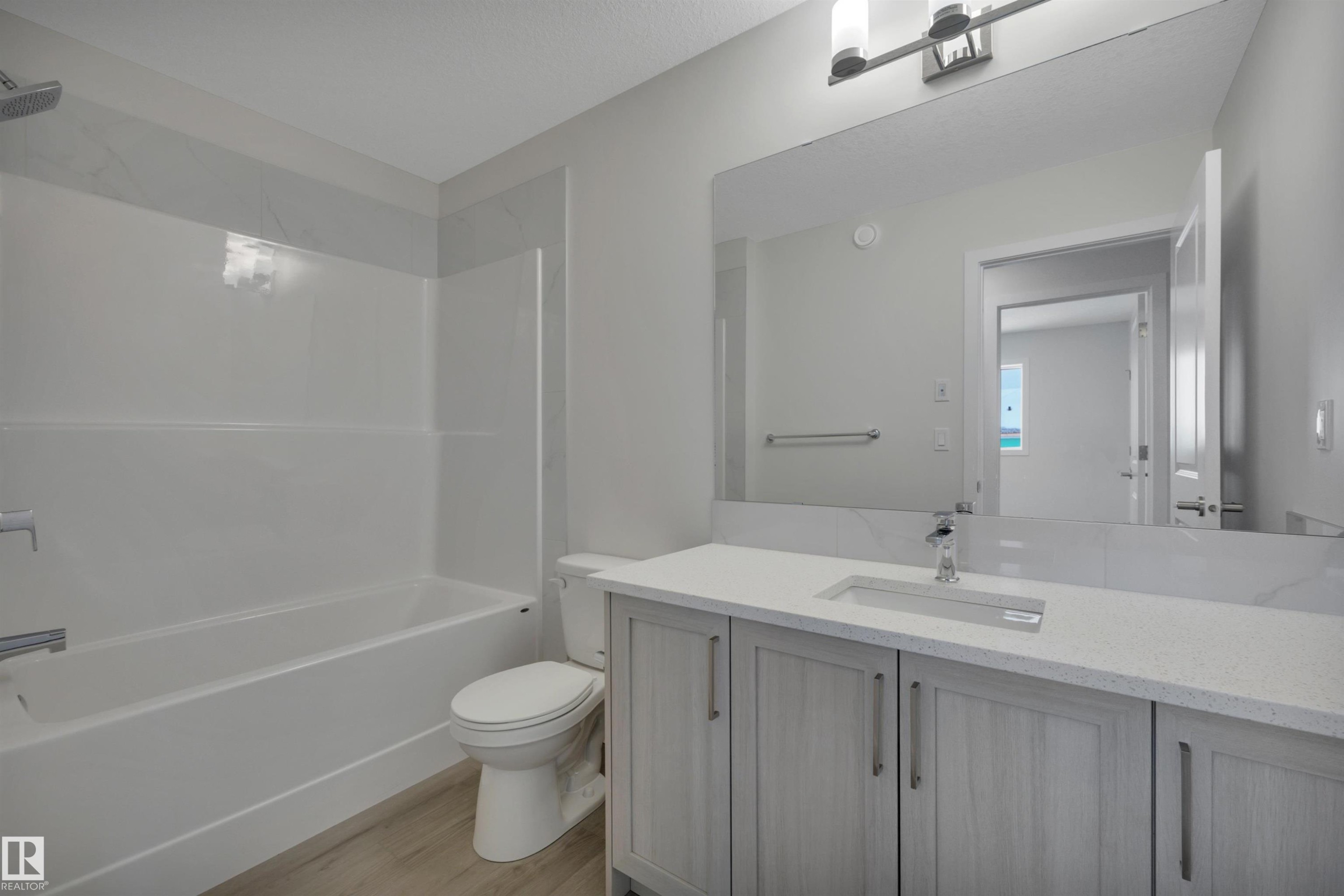 Bathroom with washtub / shower combination, vanity, and light wood-style flooring - 5742 Hawthorn Common, Edmonton, AB - Indoor Photo Showing Bathroom