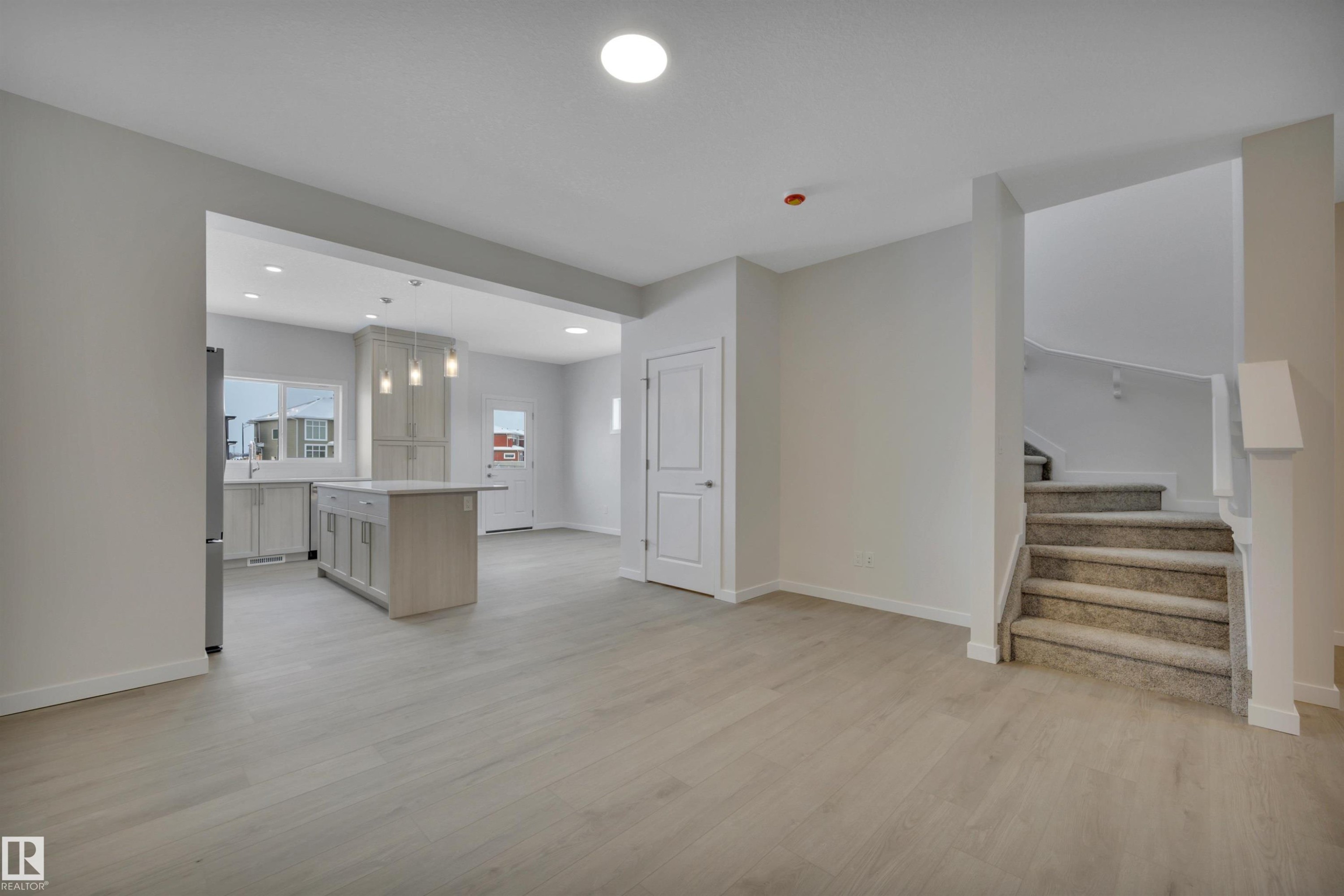 Unfurnished living room featuring light wood-style floors, stairway, and recessed lighting - 5742 Hawthorn Common, Edmonton, AB - Indoor Photo Showing Other Room