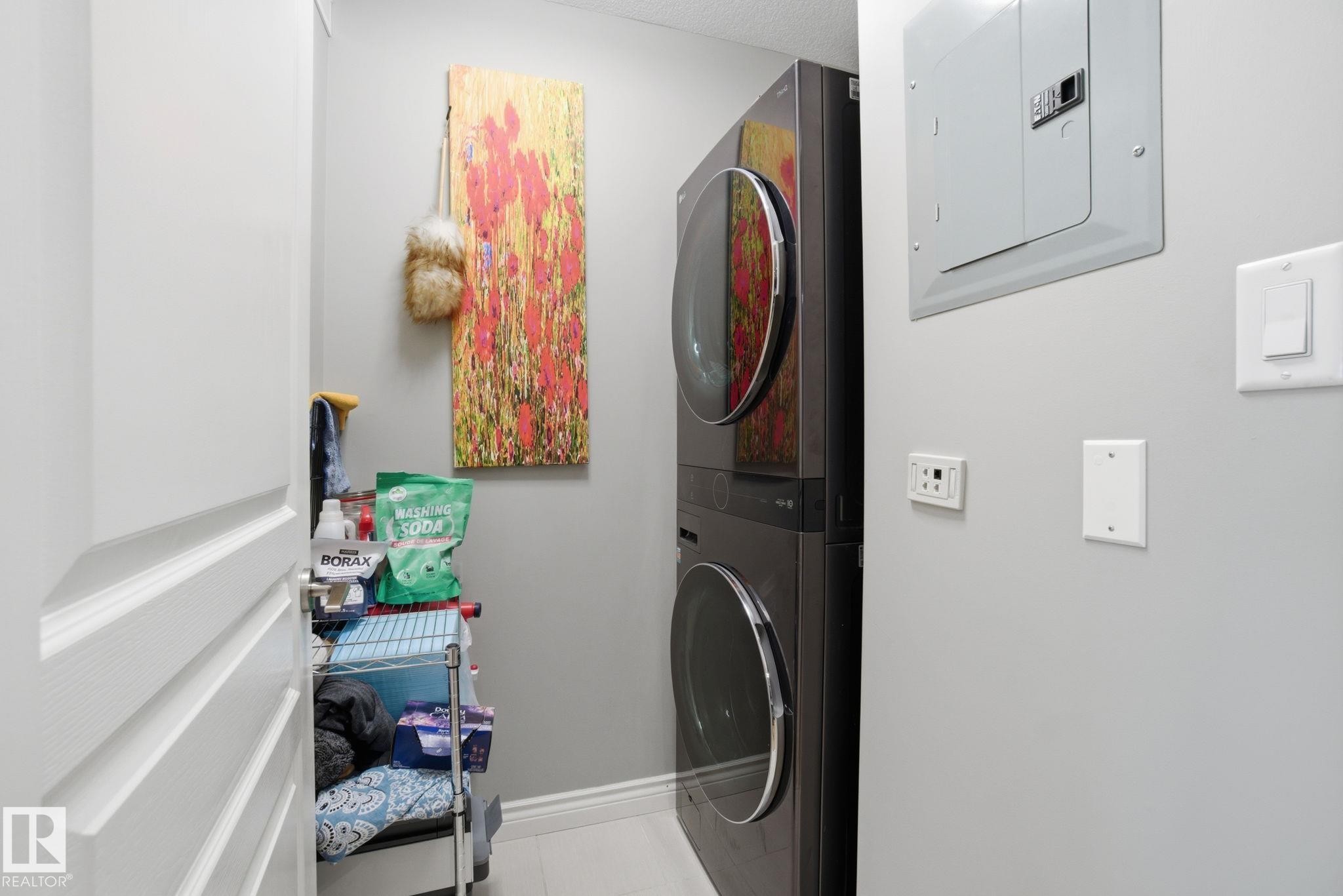 Laundry room with electric panel and estacked washer and dryer - 301 9603 98 Avenue, Edmonton, AB - Indoor Photo Showing Laundry Room