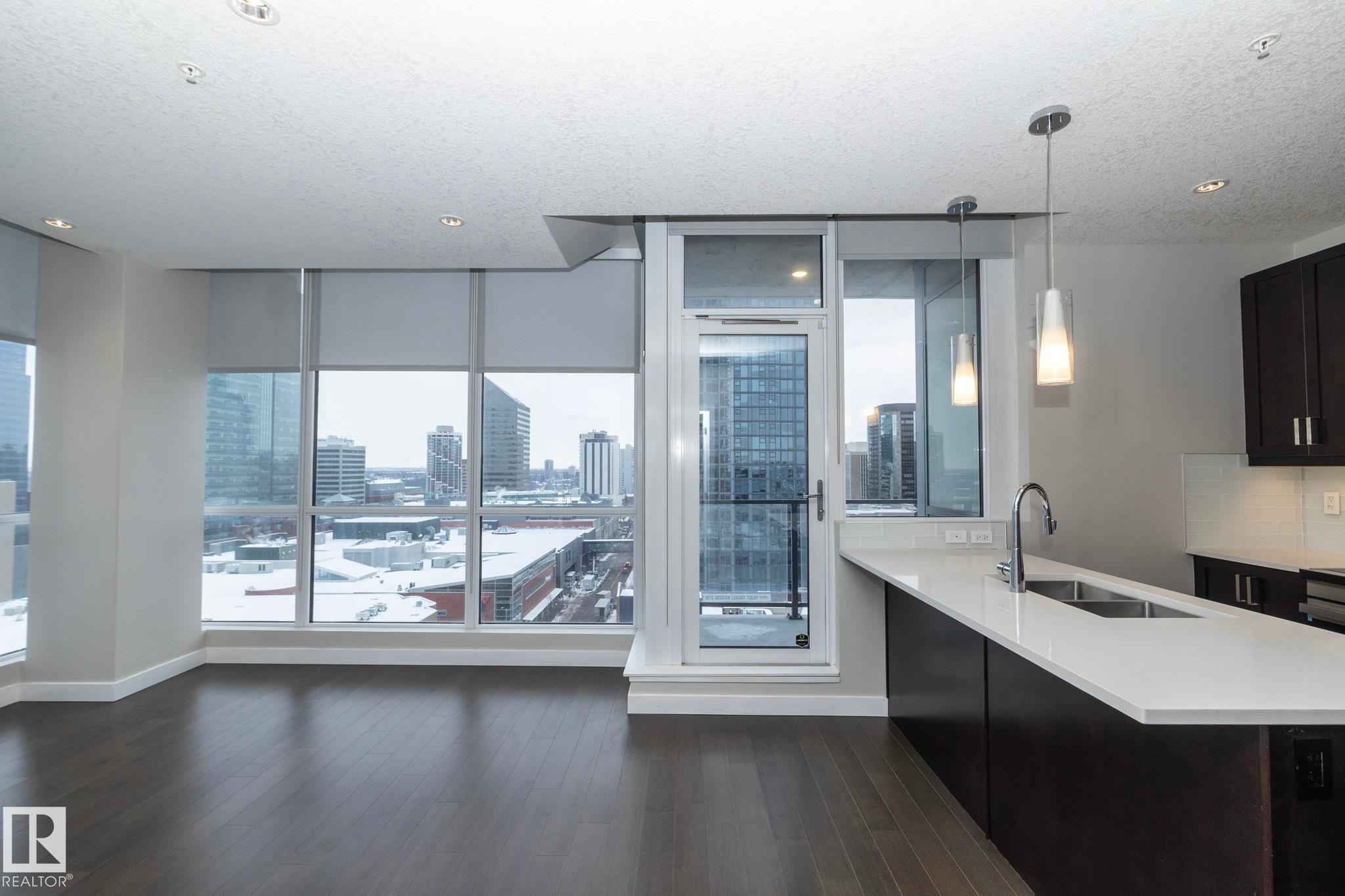 Kitchen with hanging light fixtures, plenty of natural light, decorative backsplash, a view of city, and a textured ceiling - 1201 10238 103 Street, Edmonton, AB - Indoor Photo Showing Kitchen With Double Sink With Upgraded Kitchen