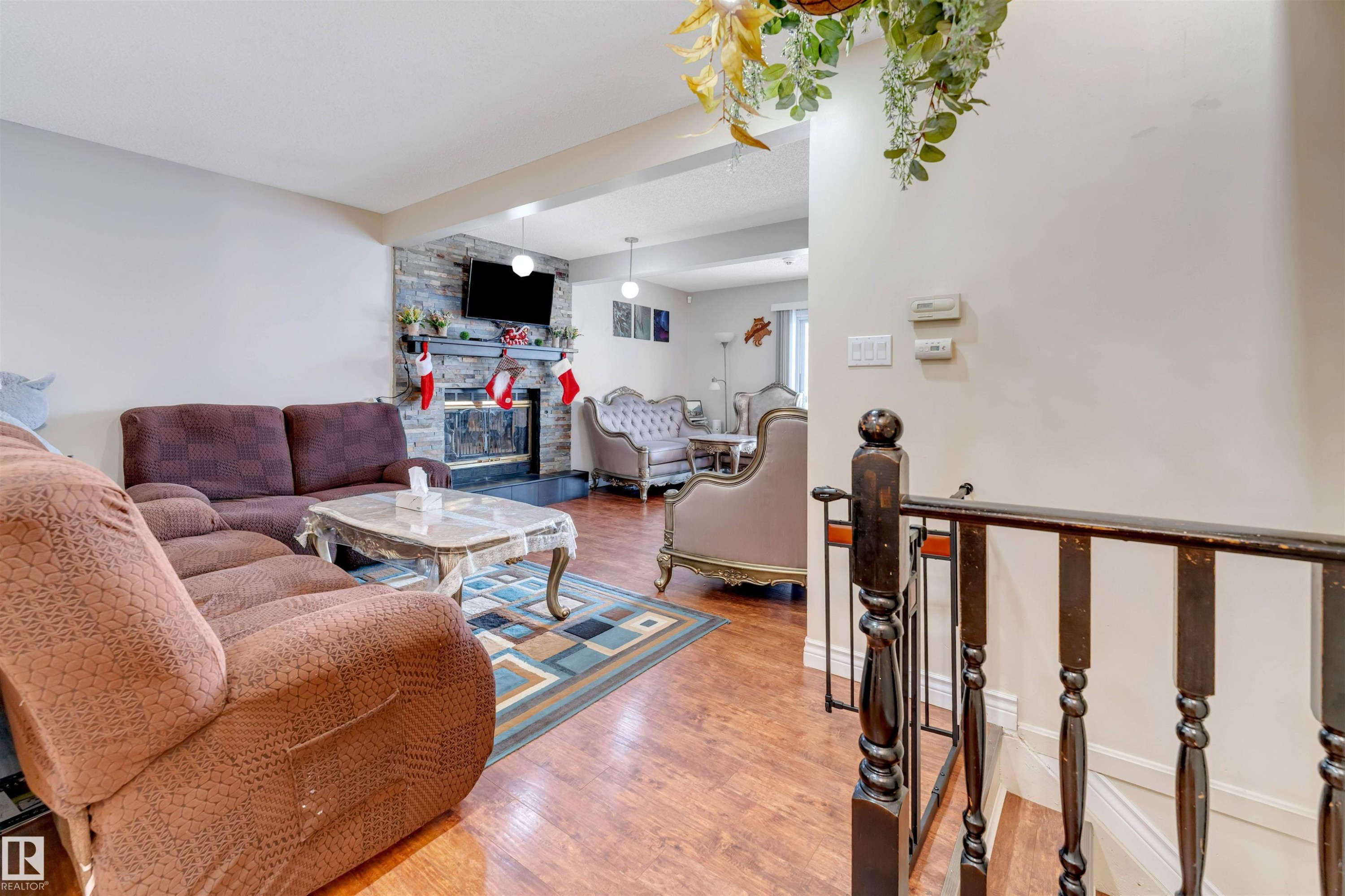 Living area with wood finished floors and a stone fireplace - 18404 97A Avenue, Edmonton, AB - Indoor