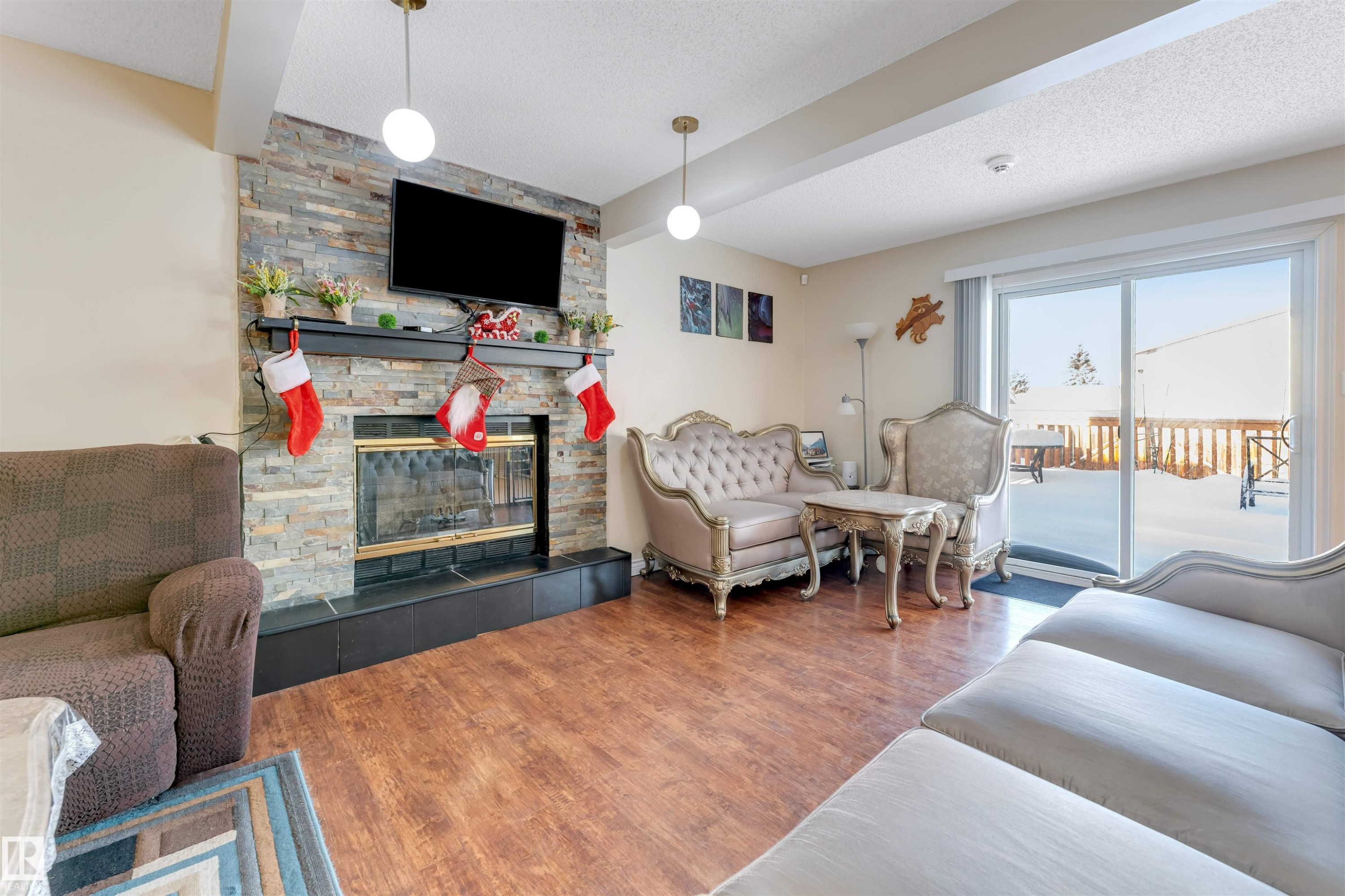 Living area featuring a textured ceiling, a fireplace, and wood finished floors - 18404 97A Avenue, Edmonton, AB - Indoor Photo Showing Living Room With Fireplace