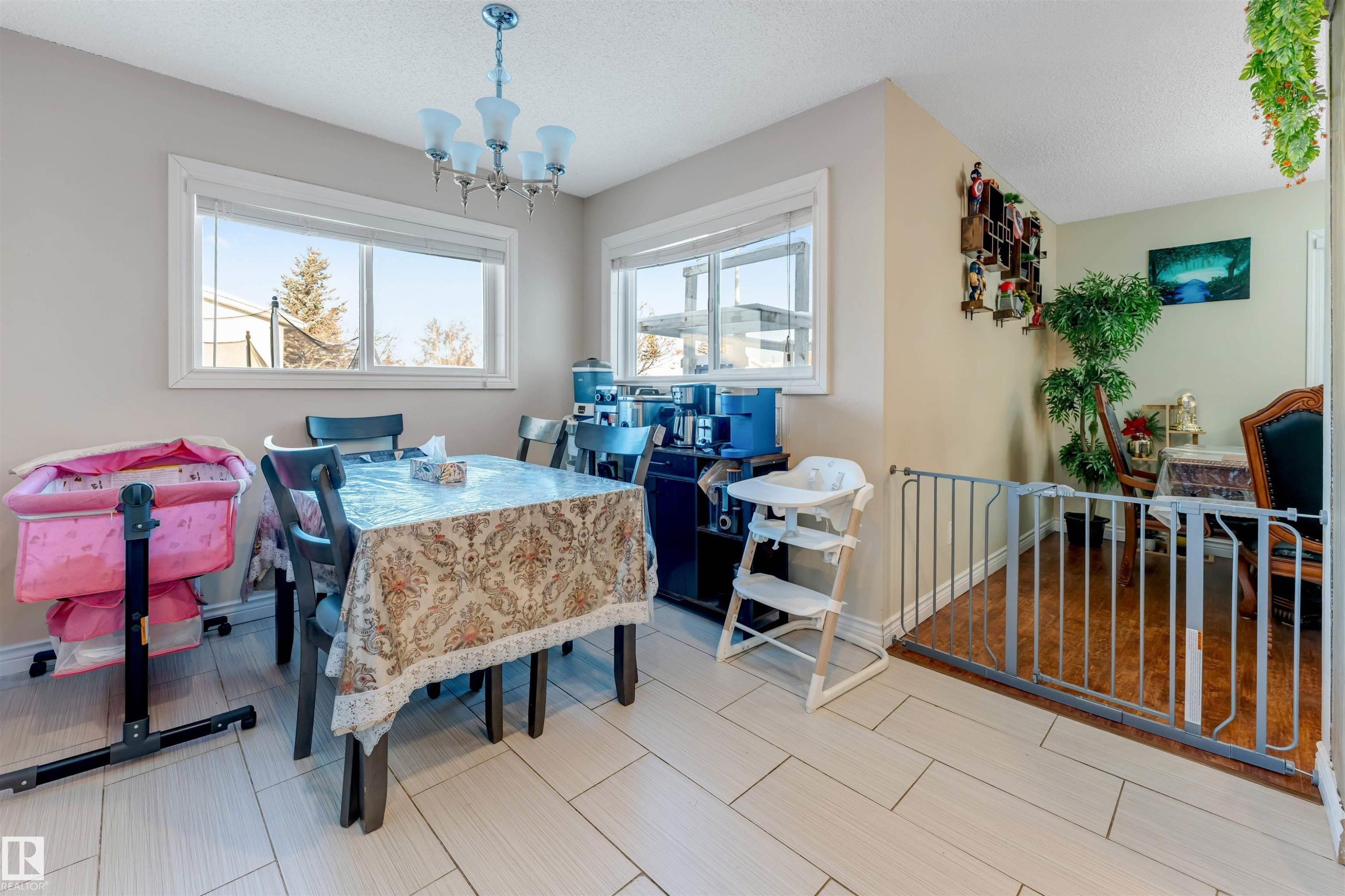Dining space with a chandelier, a textured ceiling, and wood tiled floors - 18404 97A Avenue, Edmonton, AB - Indoor Photo Showing Dining Room