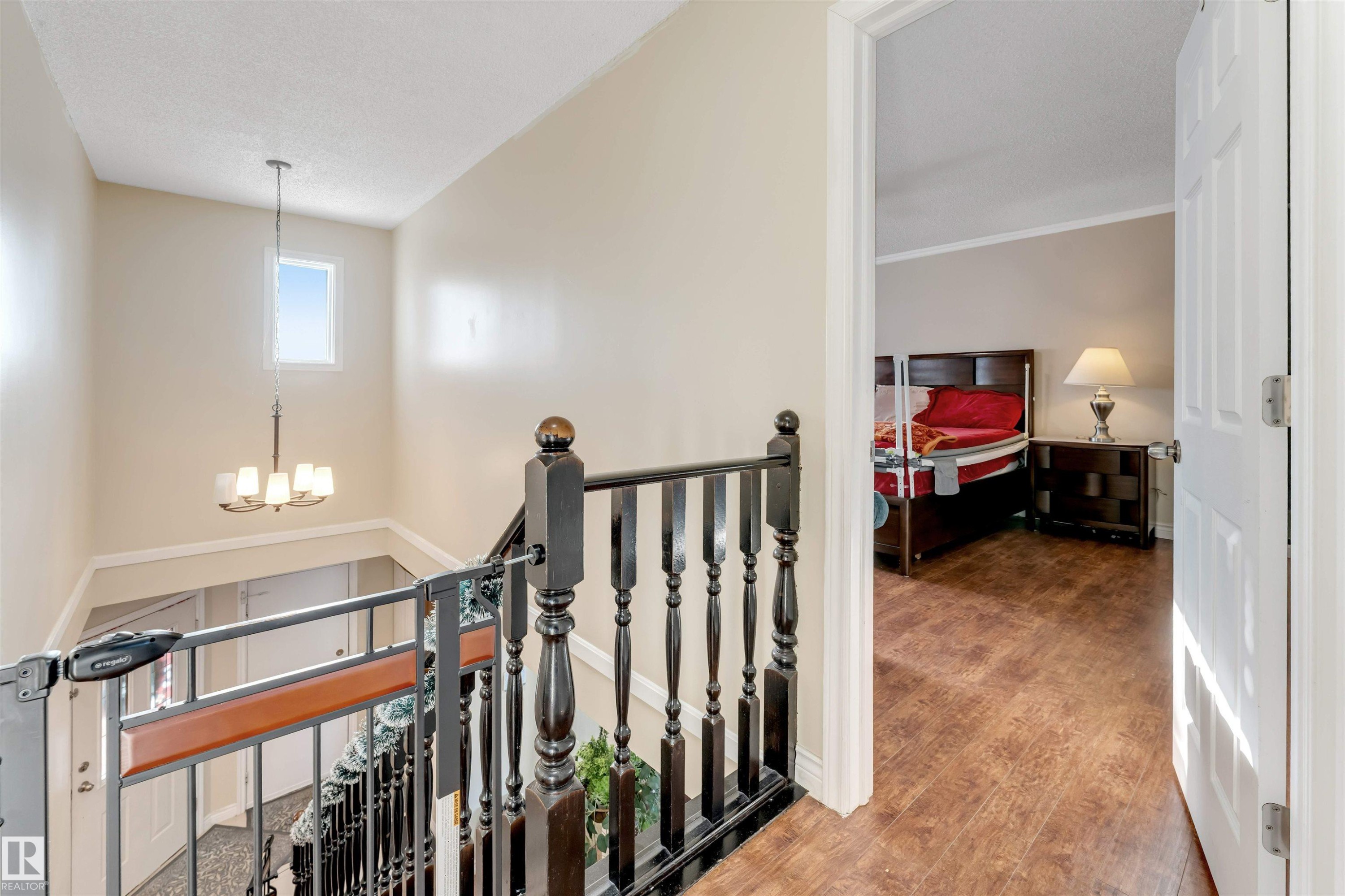 Hall featuring an upstairs landing, a chandelier, and wood finished floors - 18404 97A Avenue, Edmonton, AB - Indoor Photo Showing Other Room