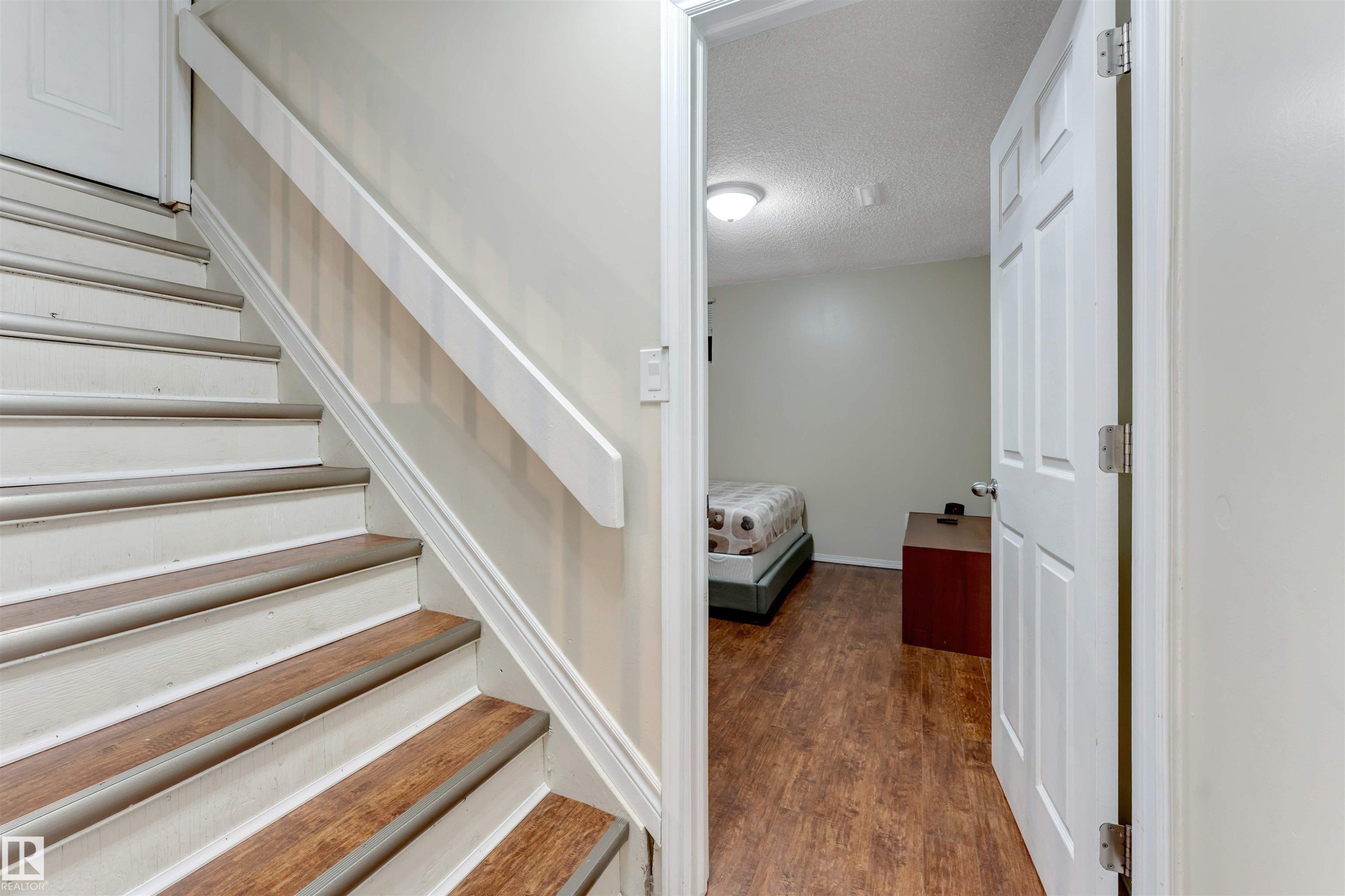 Stairway with a textured ceiling and wood finished floors - 18404 97A Avenue, Edmonton, AB - Indoor Photo Showing Other Room