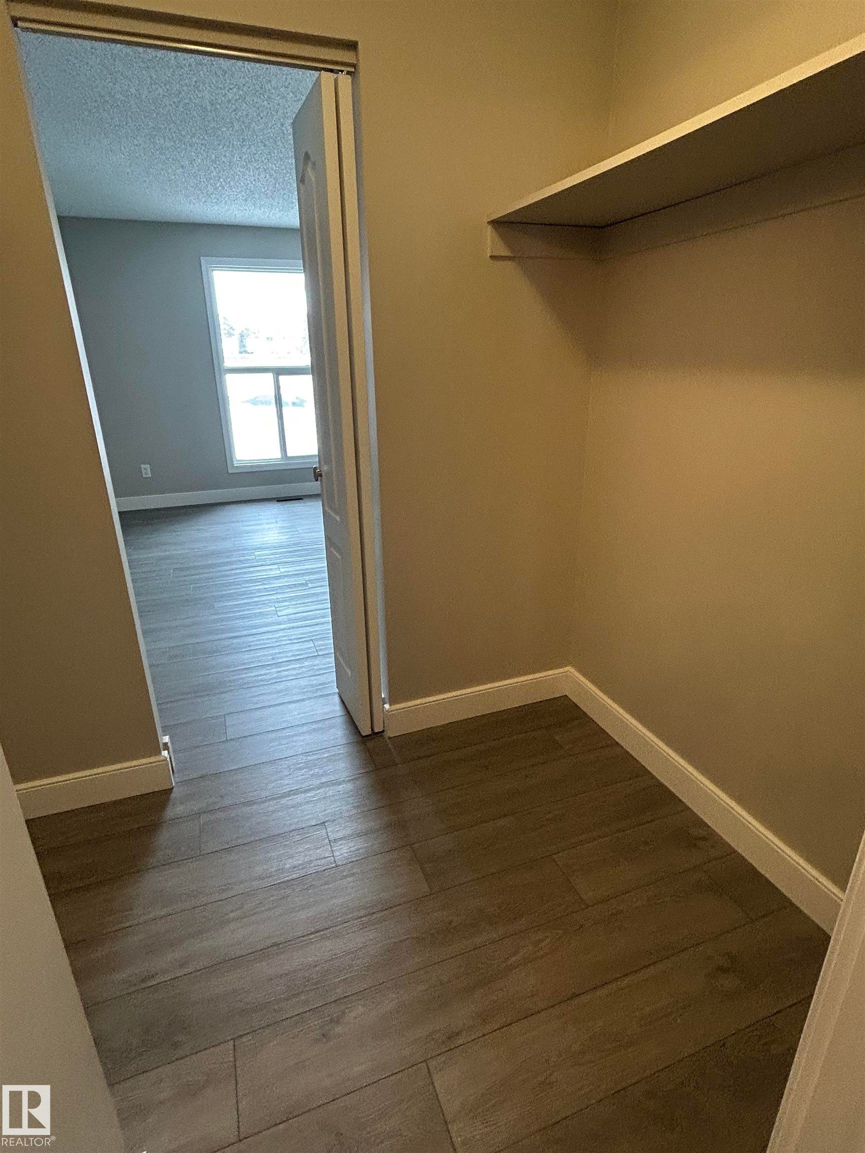 Walk in closet featuring dark wood-style floors - 53 14620 26 Street, Edmonton, AB - Indoor Photo Showing Other Room