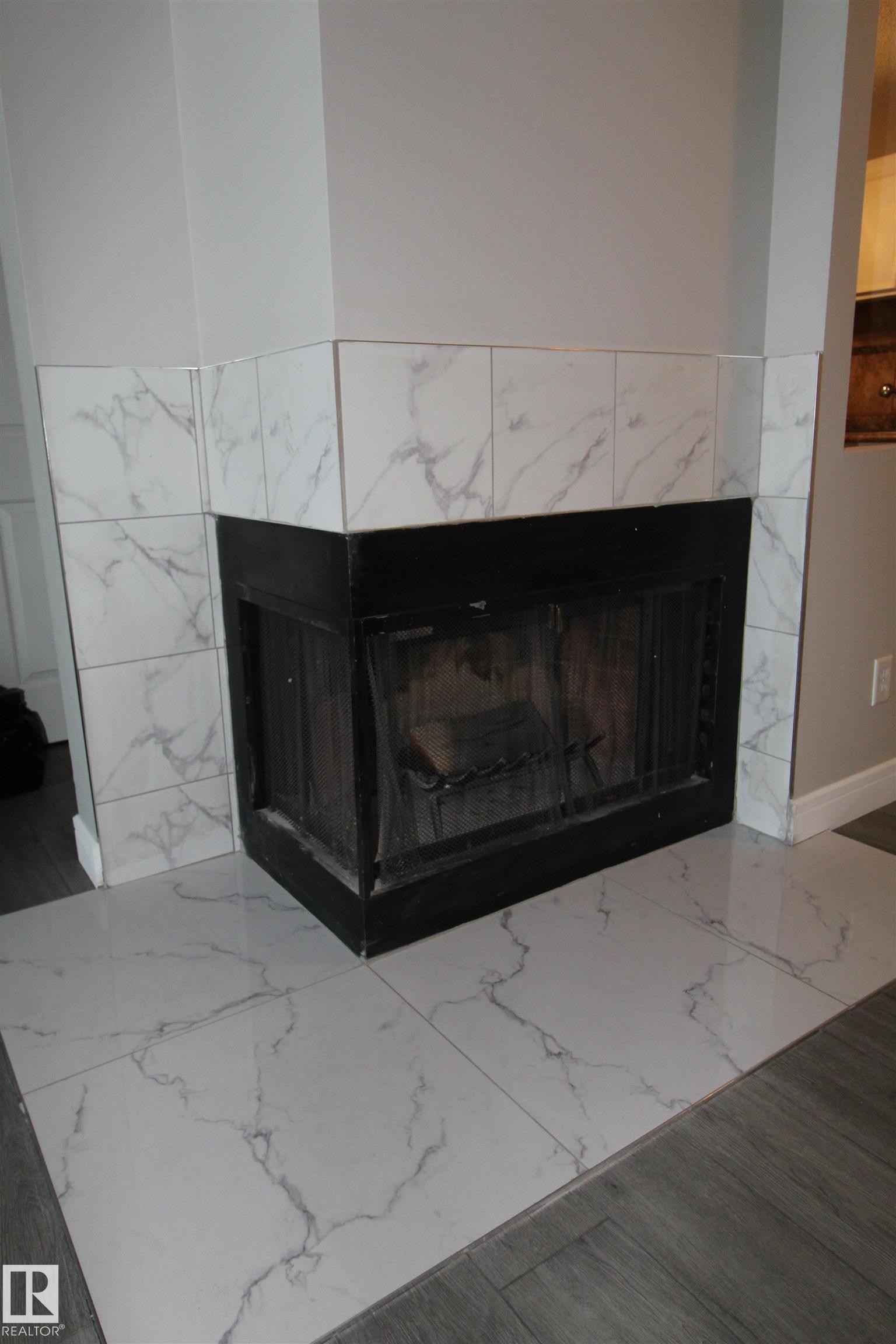 Detailed view of a high end fireplace - 53 14620 26 Street, Edmonton, AB - Indoor Photo Showing Living Room With Fireplace