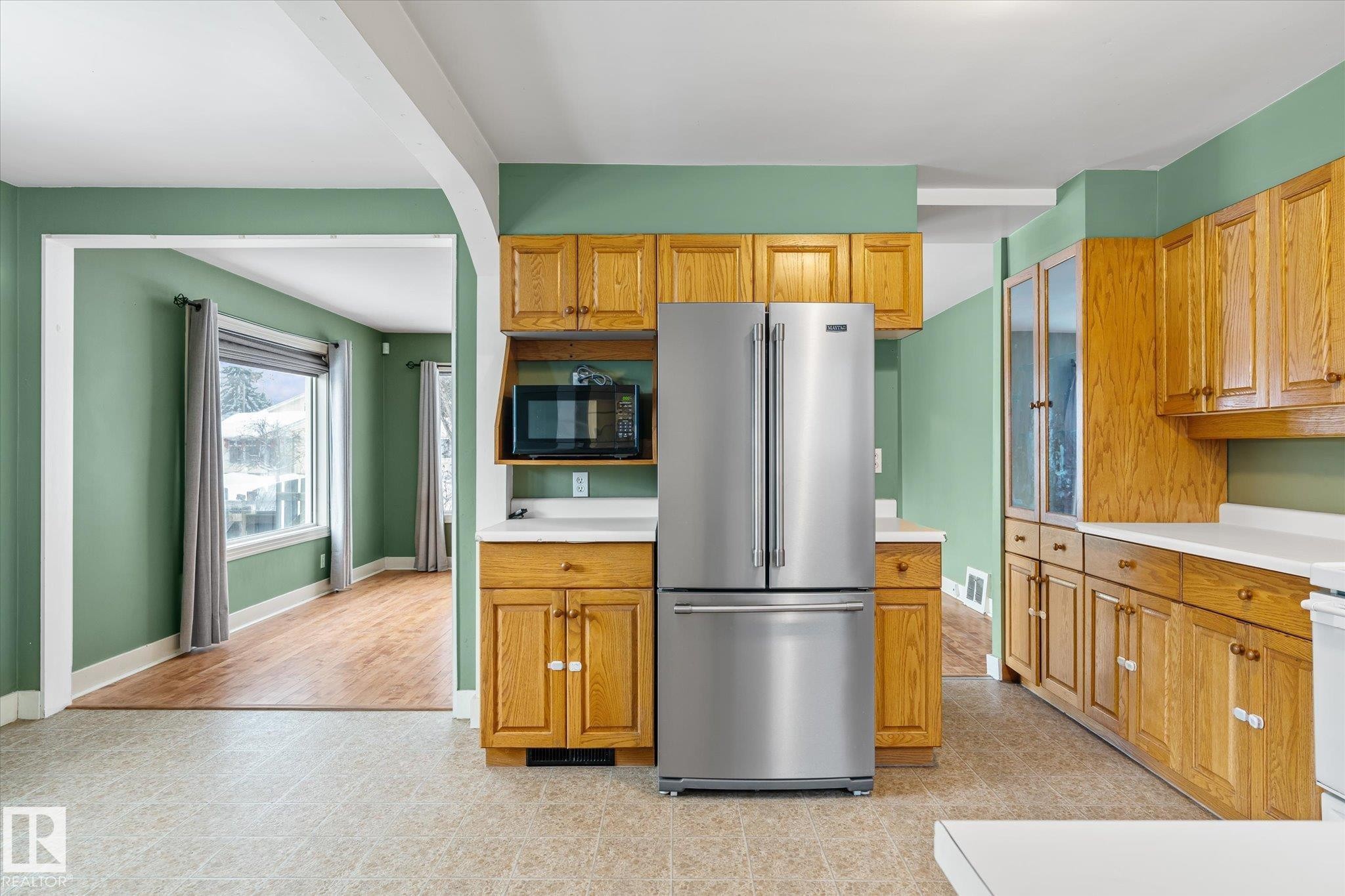 Kitchen featuring high end refrigerator, light countertops, black microwave, and brown cabinets - 10429 143 Street, Edmonton, AB - Indoor Photo Showing Kitchen