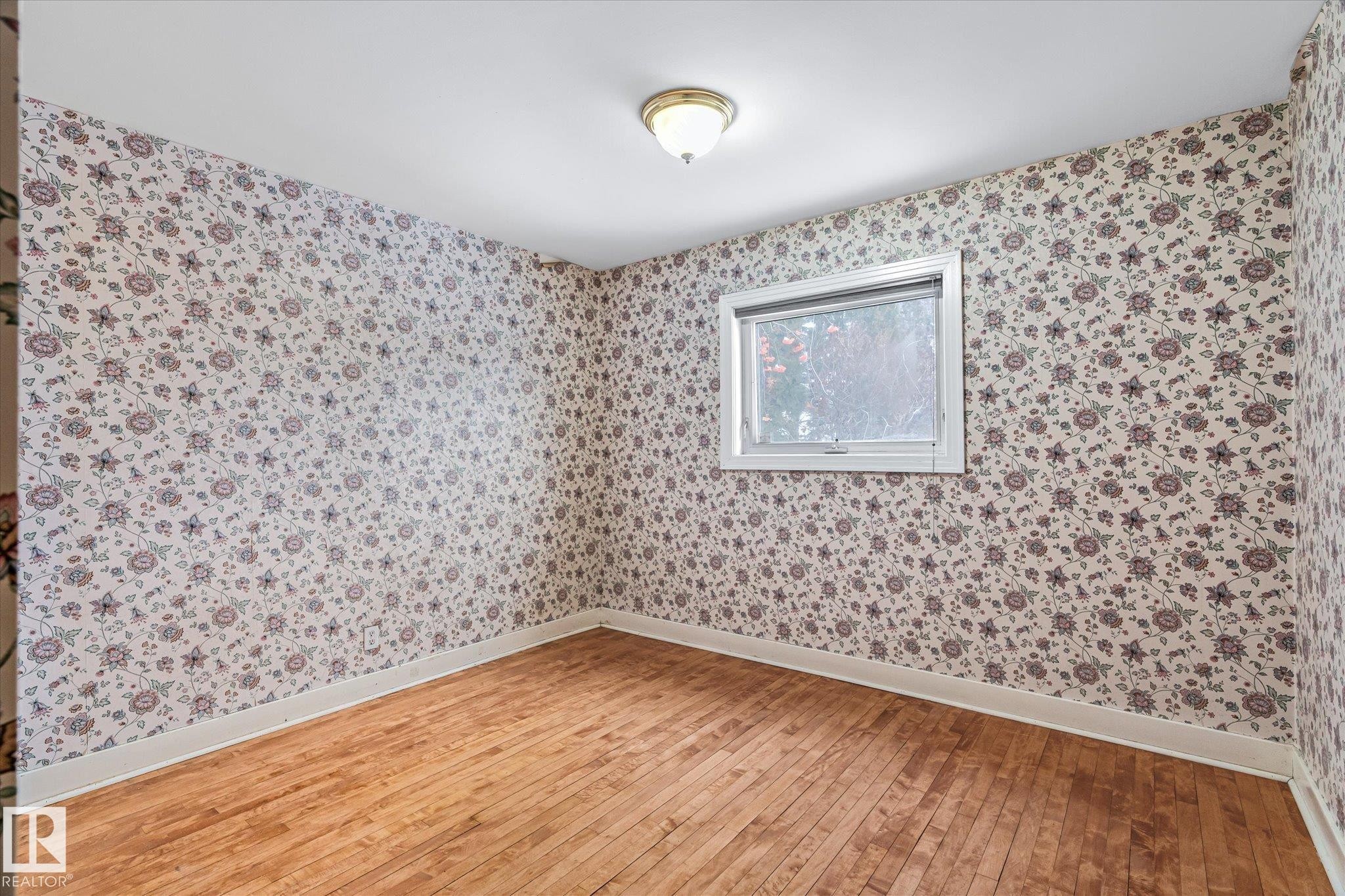 Empty room featuring light wood finished floors and wallpapered walls - 10429 143 Street, Edmonton, AB - Indoor Photo Showing Other Room