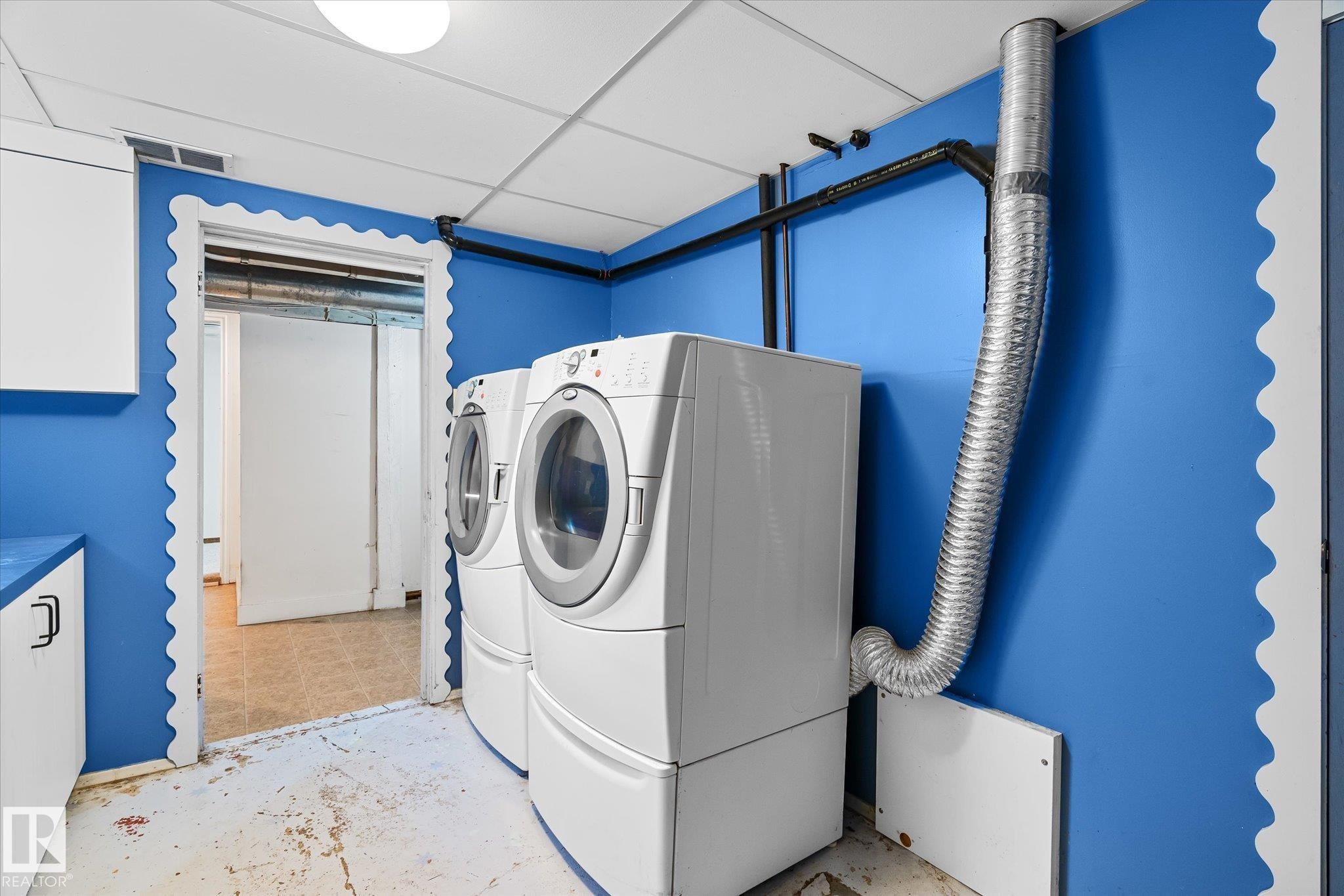Laundry area featuring separate washer and dryer, concrete floors, and a paneled ceiling - 10429 143 Street, Edmonton, AB - Indoor Photo Showing Laundry Room