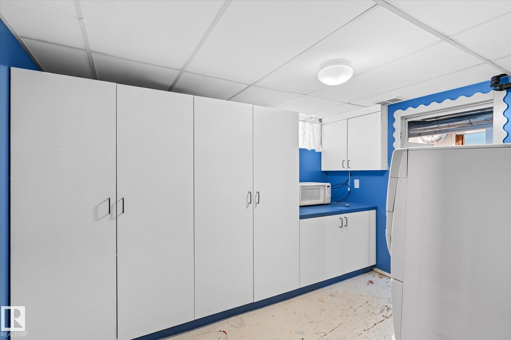 Kitchen with white appliances, white cabinets, a drop ceiling, and concrete flooring - 10429 143 Street, Edmonton, AB - Indoor