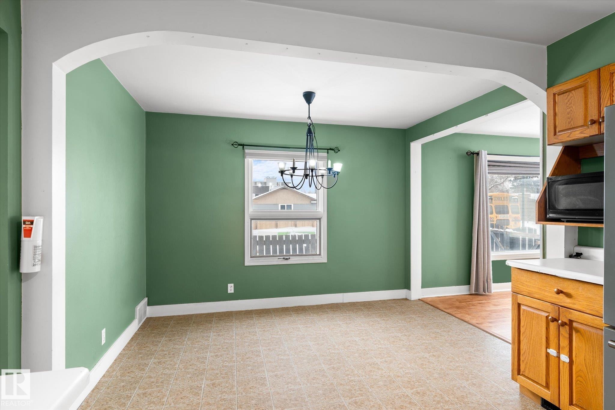 Unfurnished dining area featuring arched walkways, plenty of natural light, and a chandelier - 10429 143 Street, Edmonton, AB - Indoor Photo Showing Other Room