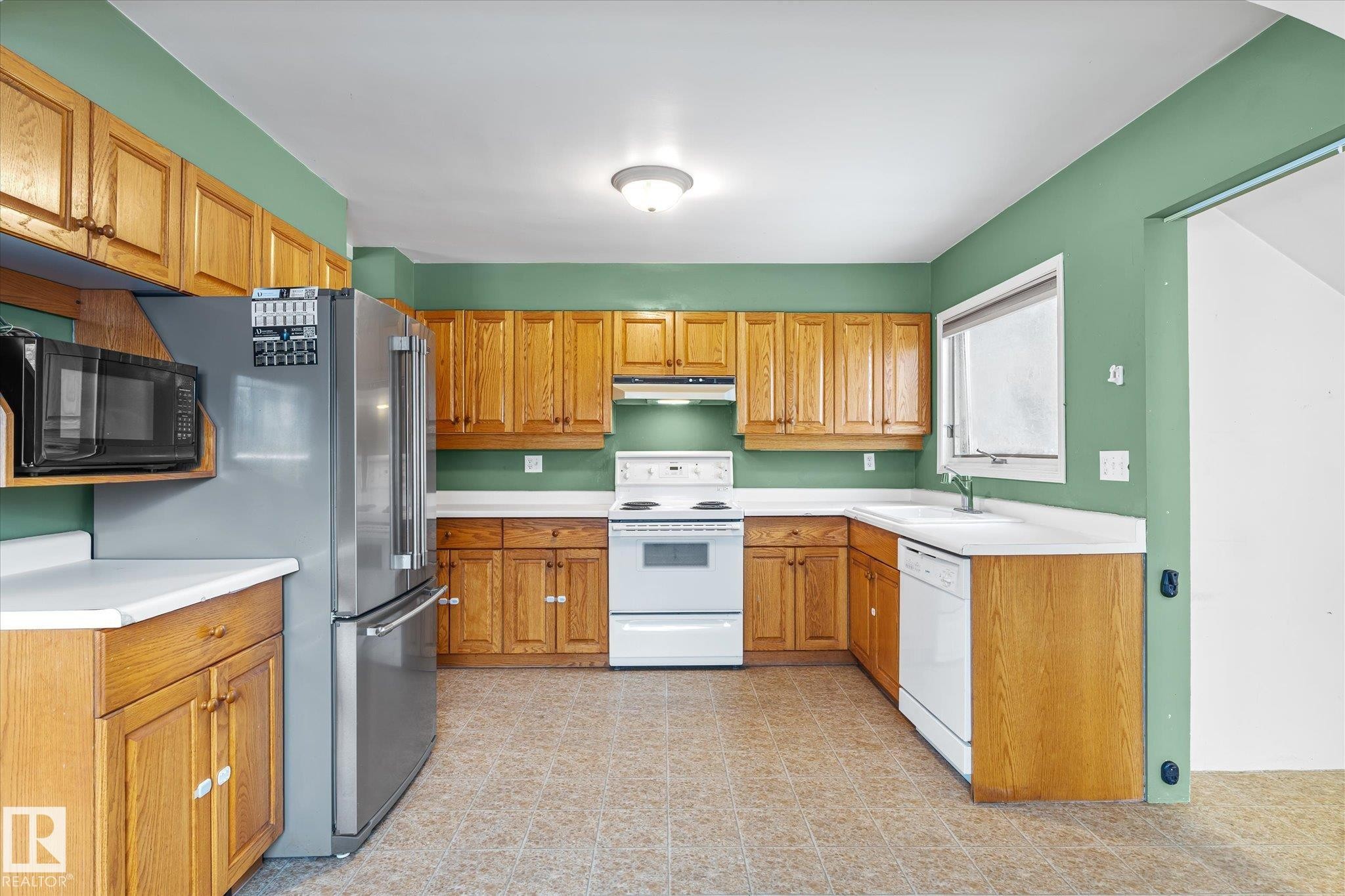 Kitchen with white appliances, light countertops, under cabinet range hood, and light flooring - 10429 143 Street, Edmonton, AB - Indoor Photo Showing Kitchen