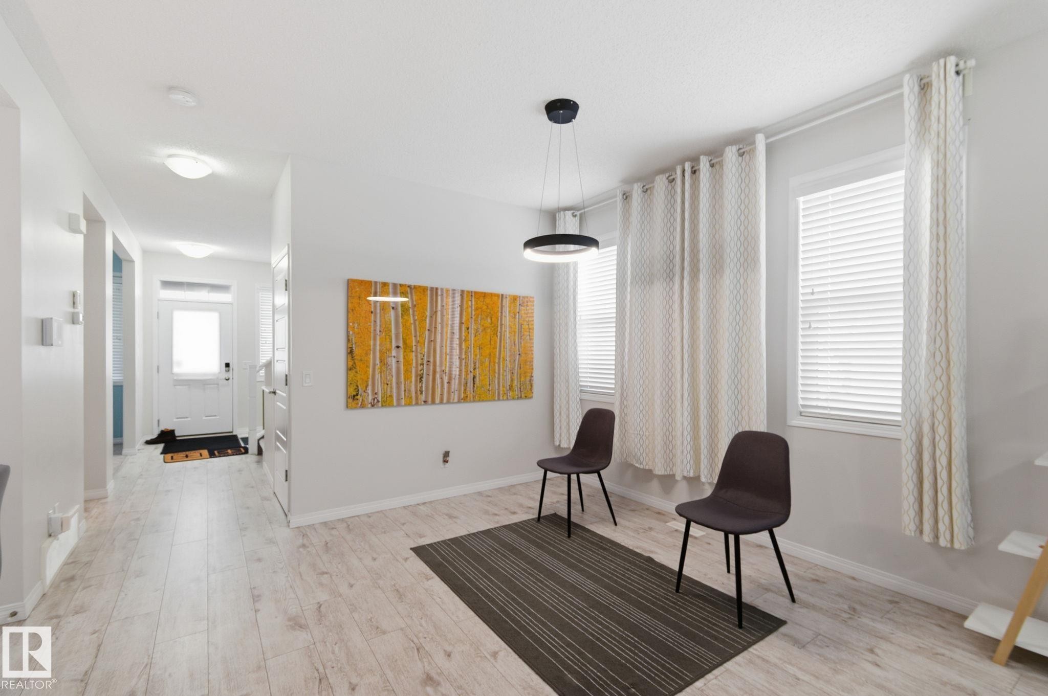 Living area with healthy amount of natural light and light wood-style floors - 1511 Secord Rd, Edmonton, AB - Indoor Photo Showing Other Room