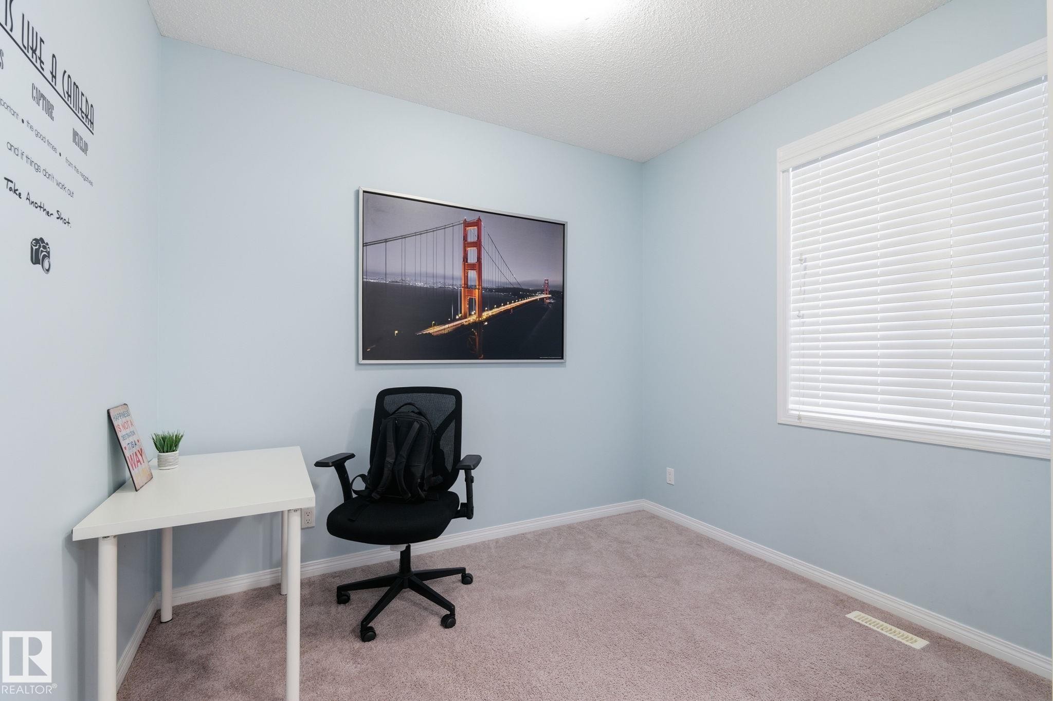Carpeted office space with baseboards and a textured ceiling - 1511 Secord Rd, Edmonton, AB - Indoor
