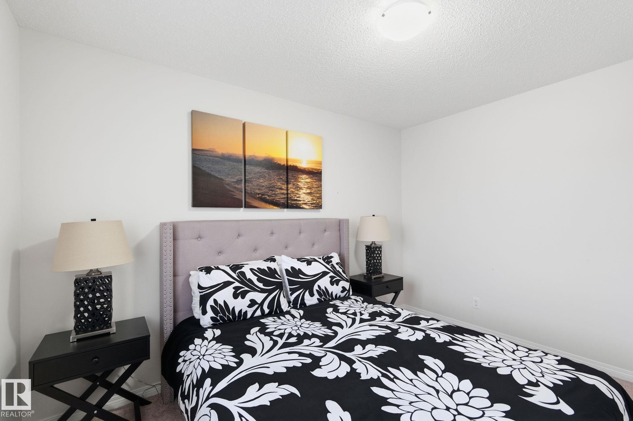 Carpeted bedroom featuring a textured ceiling and baseboards - 1511 Secord Rd, Edmonton, AB - Indoor Photo Showing Bedroom
