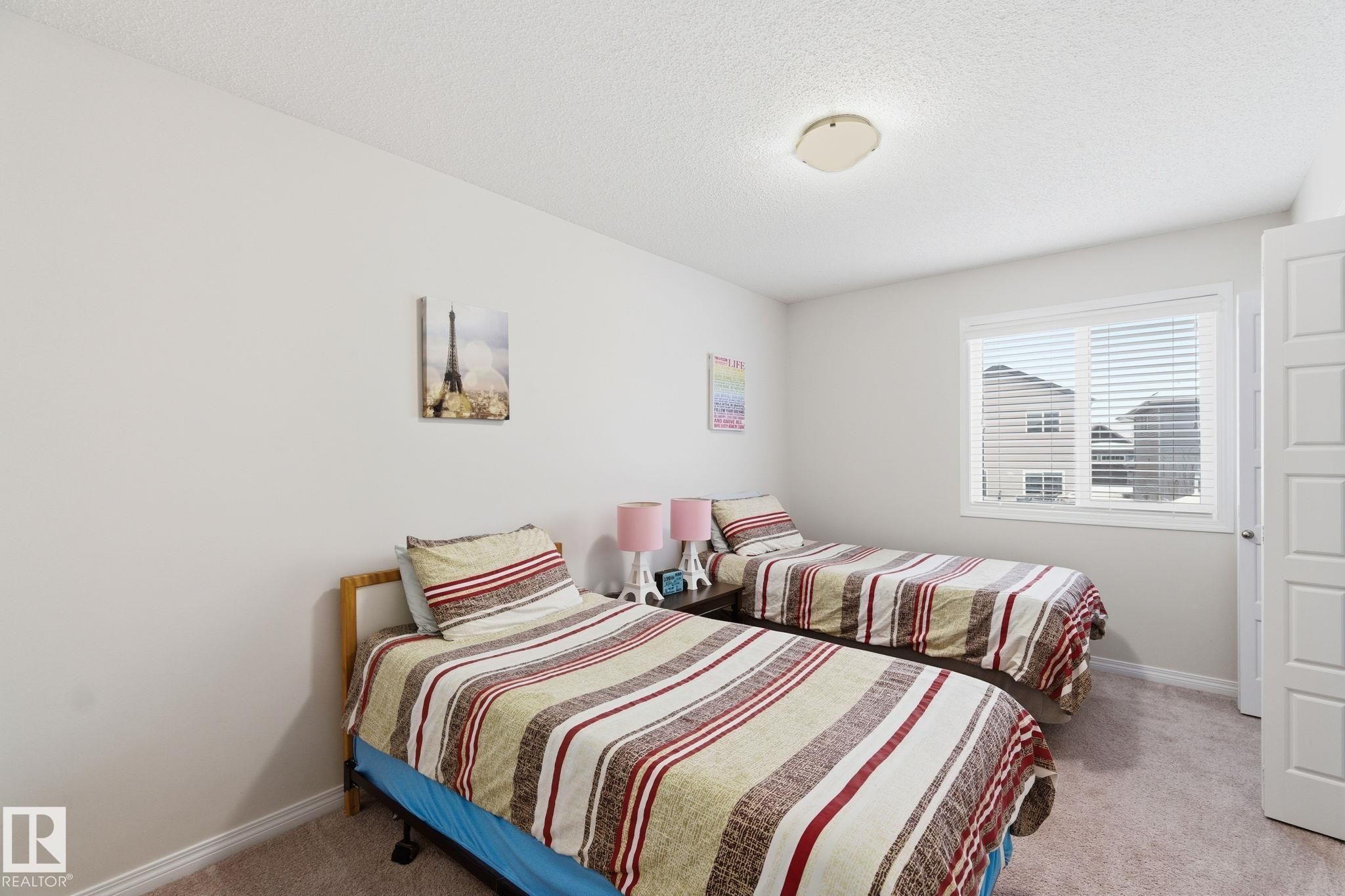 Bedroom featuring light carpet and a textured ceiling - 1511 Secord Rd, Edmonton, AB - Indoor Photo Showing Bedroom